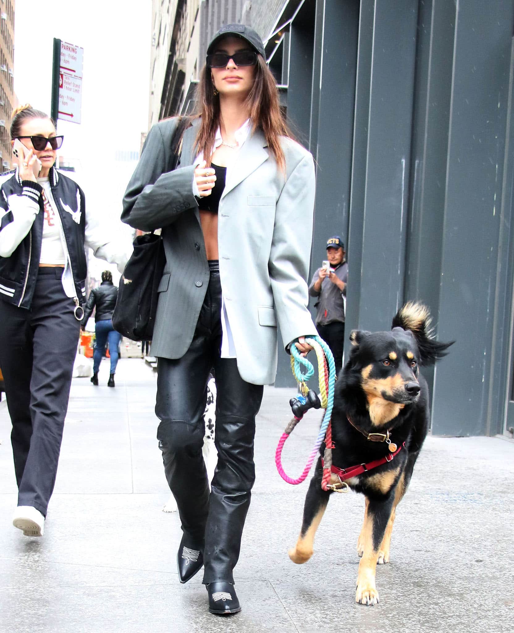 Emily Ratajkowski grounds her off-duty look with Sonora Santa Fe leather western boots, pairing the pointed-toe style with black leather pants and an oversized blazer while walking her dog, Colombo, in New York City