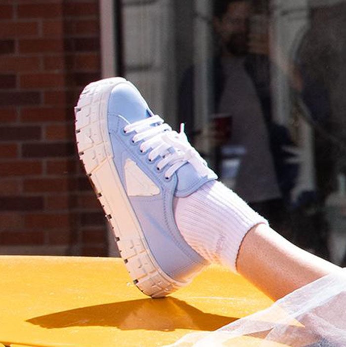 Gigi Hadid grounds her powder-blue look with Prada Double Wheel sneakers, their ridged rubber sole adding weight and contrast to the airy tulle