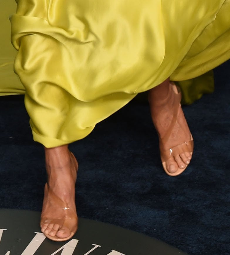 Heidi Klum highlights her pedicure in Gianvito Rossi’s beige “Metropolis” sandals, the barely-there PVC straps and sleek stiletto heel creating a leg-lengthening finish beneath her flowing yellow gown
