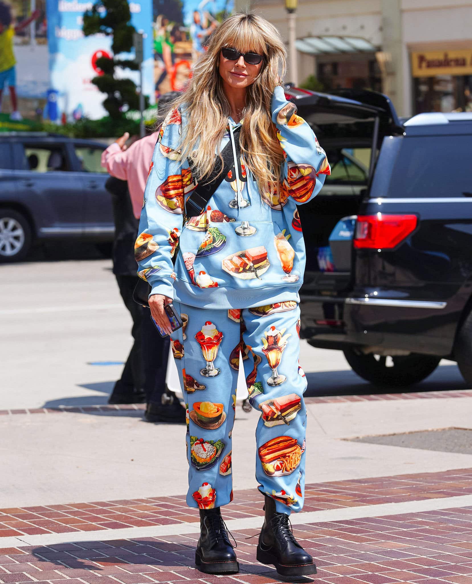 Heidi Klum makes a playful entrance at the America’s Got Talent Season 17 auditions in Pasadena on April 1, 2022, pairing her Moschino diner-print tracksuit with chunky black R13 stack platform boots that add a grunge edge to the whimsical look