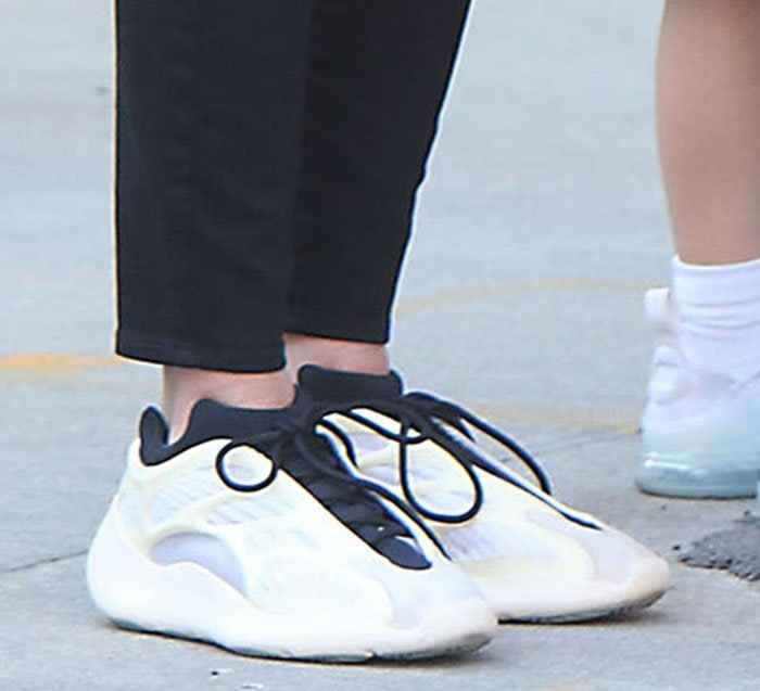 Nicky Hilton sports the Adidas Yeezy 700 V3 Azael sneakers, featuring a sleek monofilament-engineered mesh upper with translucent RPU overlays, a chunky EVA foam midsole, and a futuristic herringbone-patterned rubber outsole