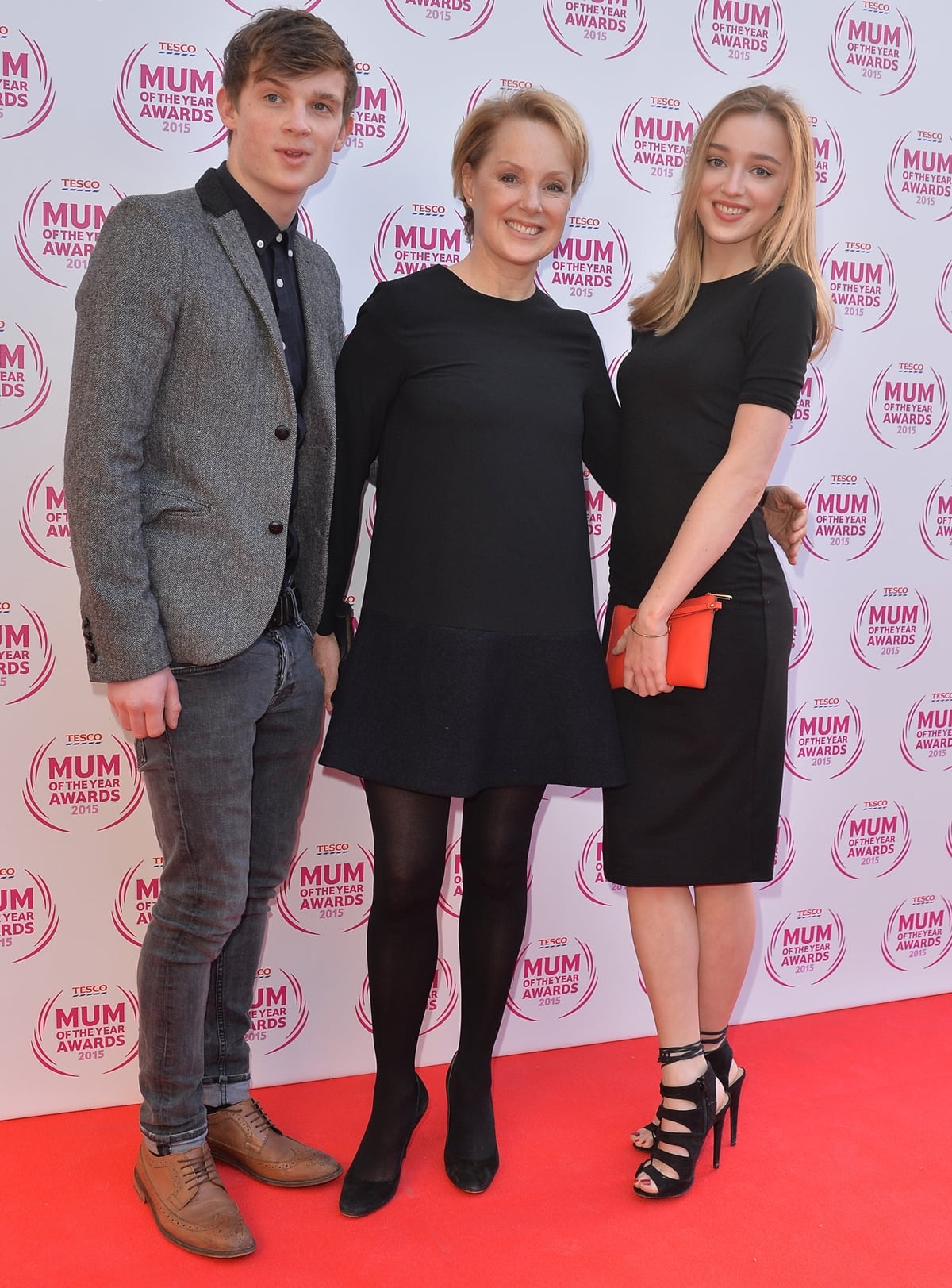 Sally Dynevor attends the Tesco Mum of the Year Awards at The Savoy Hotel on March 1, 2015, in London with her children Samuel and Phoebe, who turned heads in a fitted black dress, strappy platform heels, and a bold orange clutch