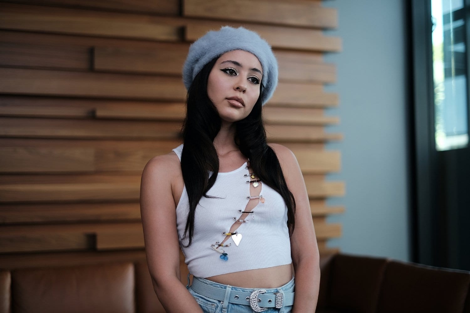 Alexa Demie, who plays Maddy Perez in HBO’s Euphoria, channels her character’s edgy Y2K-inspired style in a cropped white tank with safety-pin embellishments, high-waisted denim with a crystal-studded belt, and a soft powder-blue beret