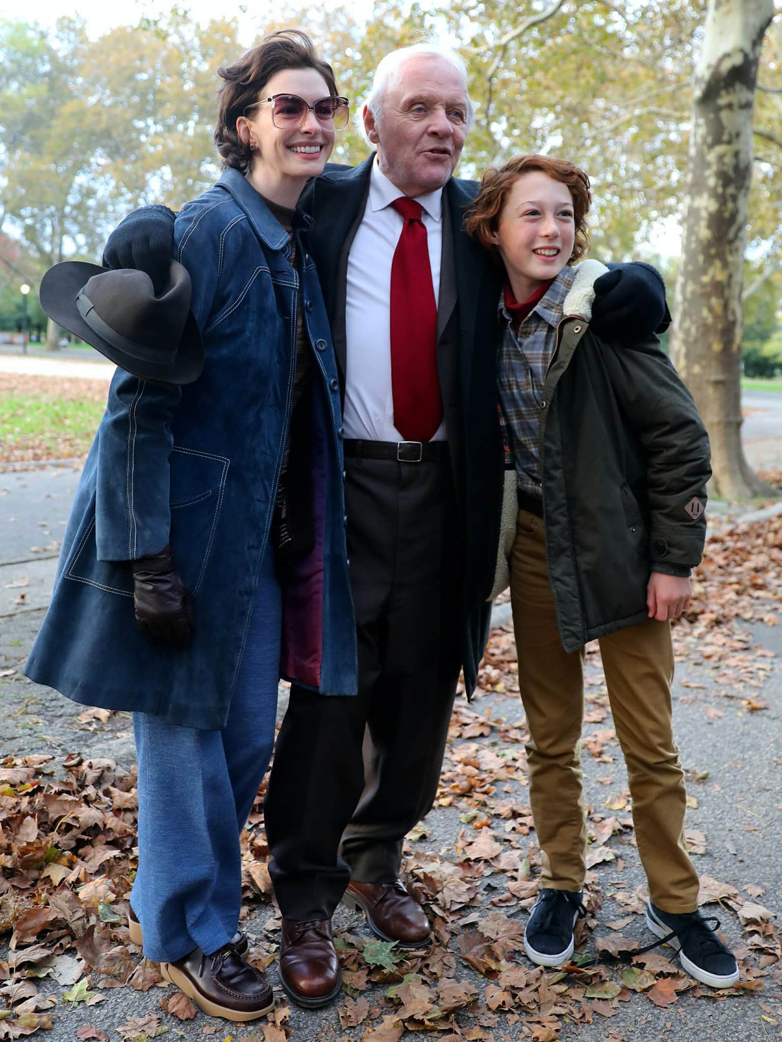 Anne Hathaway, Anthony Hopkins, and Michael Banks Repeta share a moment on set for James Gray’s Armageddon Time, with Hathaway grounding her retro look in chunky platform lace-ups