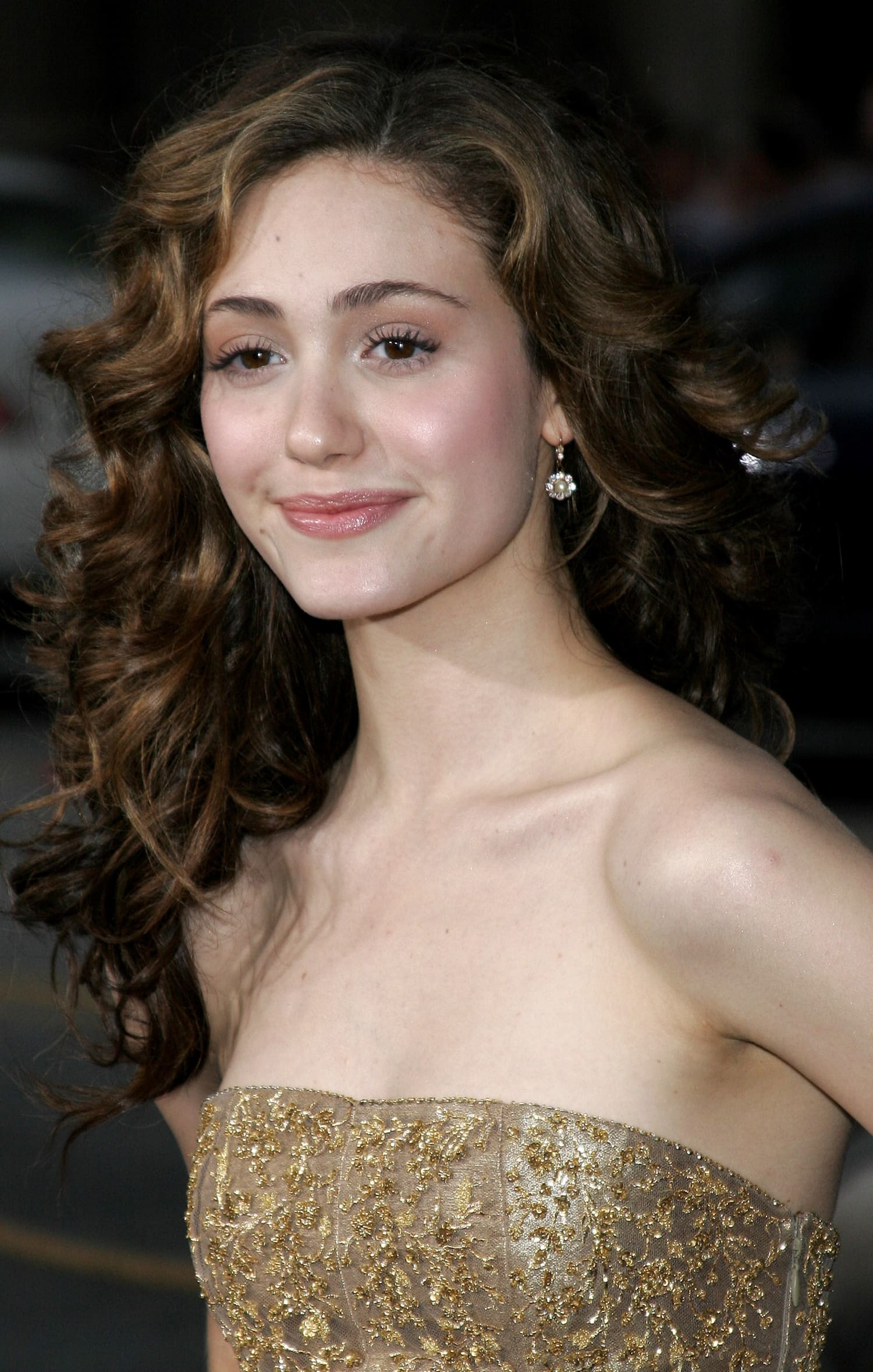 Emmy Rossum, radiant in a gold embroidered strapless gown, at the Poseidon premiere—she landed the role of Jennifer Ramsey after Lindsay Lohan declined the part
