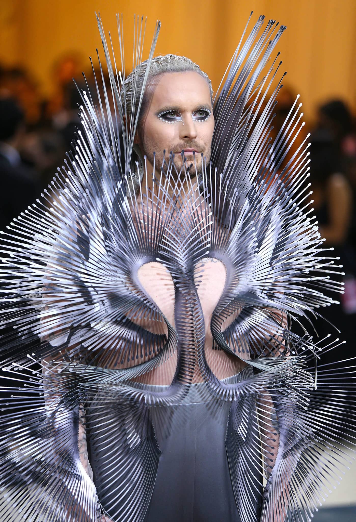 A close-up of Fredrik Robertsson's custom Iris van Herpen "Quantum" ensemble reveals its intricate metallic spikes, sculptural swan-inspired motif, and dramatic crystal-lined eye makeup