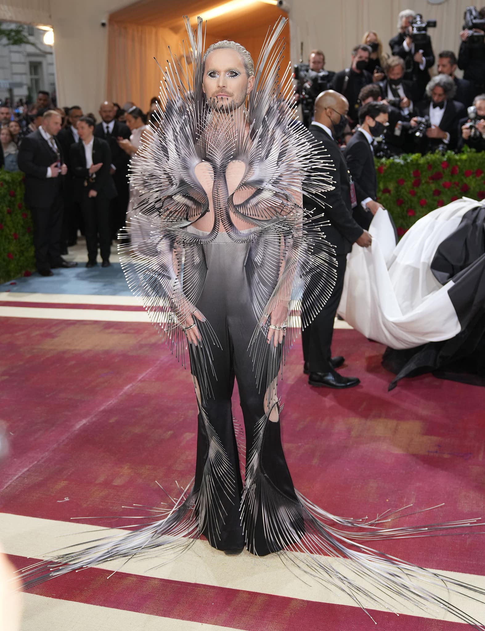 Fredrik Robertsson arrives at the 2022 Met Gala in Iris van Herpen's sculptural "Quantum" creation, featuring radiating metallic elements, dramatic eye makeup, and a silhouette that briefly led onlookers to mistake him for Jared Leto