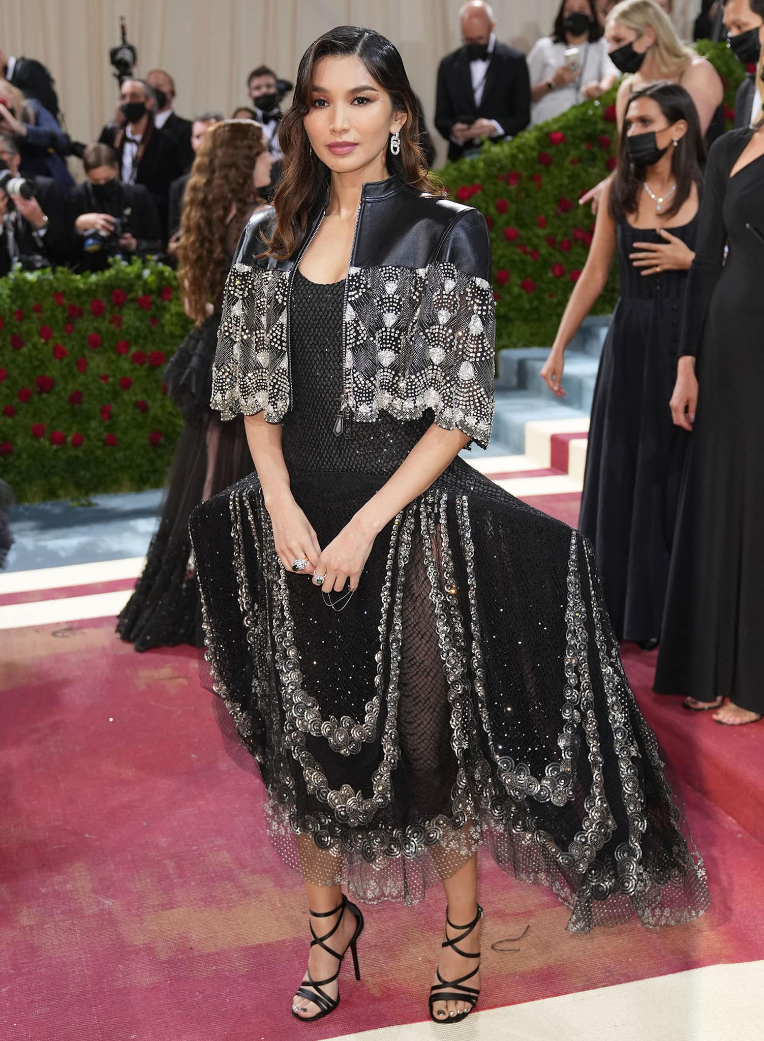 Gemma Chan elevates her crystal-embroidered Louis Vuitton gown with black strappy gladiator heels that accentuate her long legs and add a bold, sculptural finish to her Met Gala look