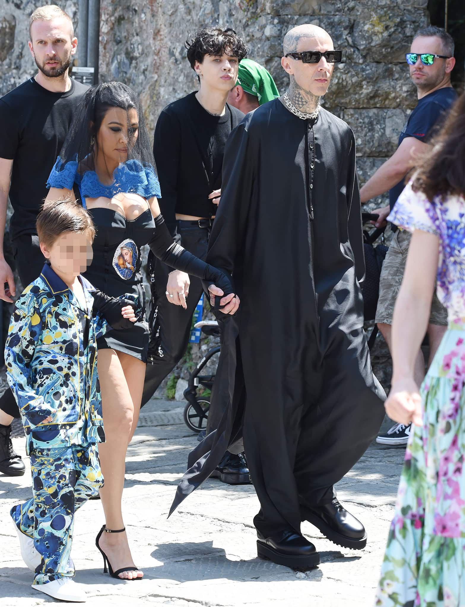Kourtney Kardashian steps out in a vintage Dolce Gabbana Virgin Mary mini dress paired with sheer gloves and black ankle-strap stiletto sandals as she joins Travis Barker en route to their pre-wedding lunch at the Abbey of San Fruttuoso in Portofino on May 21, 2022