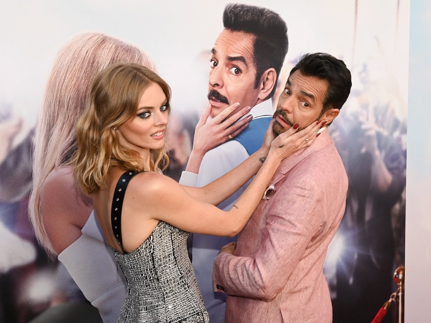 Samara Weaving playfully poses with co-star Eugenio Derbez at The Valet premiere, her embellished Louis Vuitton gown adding a touch of edgy glamour to the lighthearted red-carpet moment