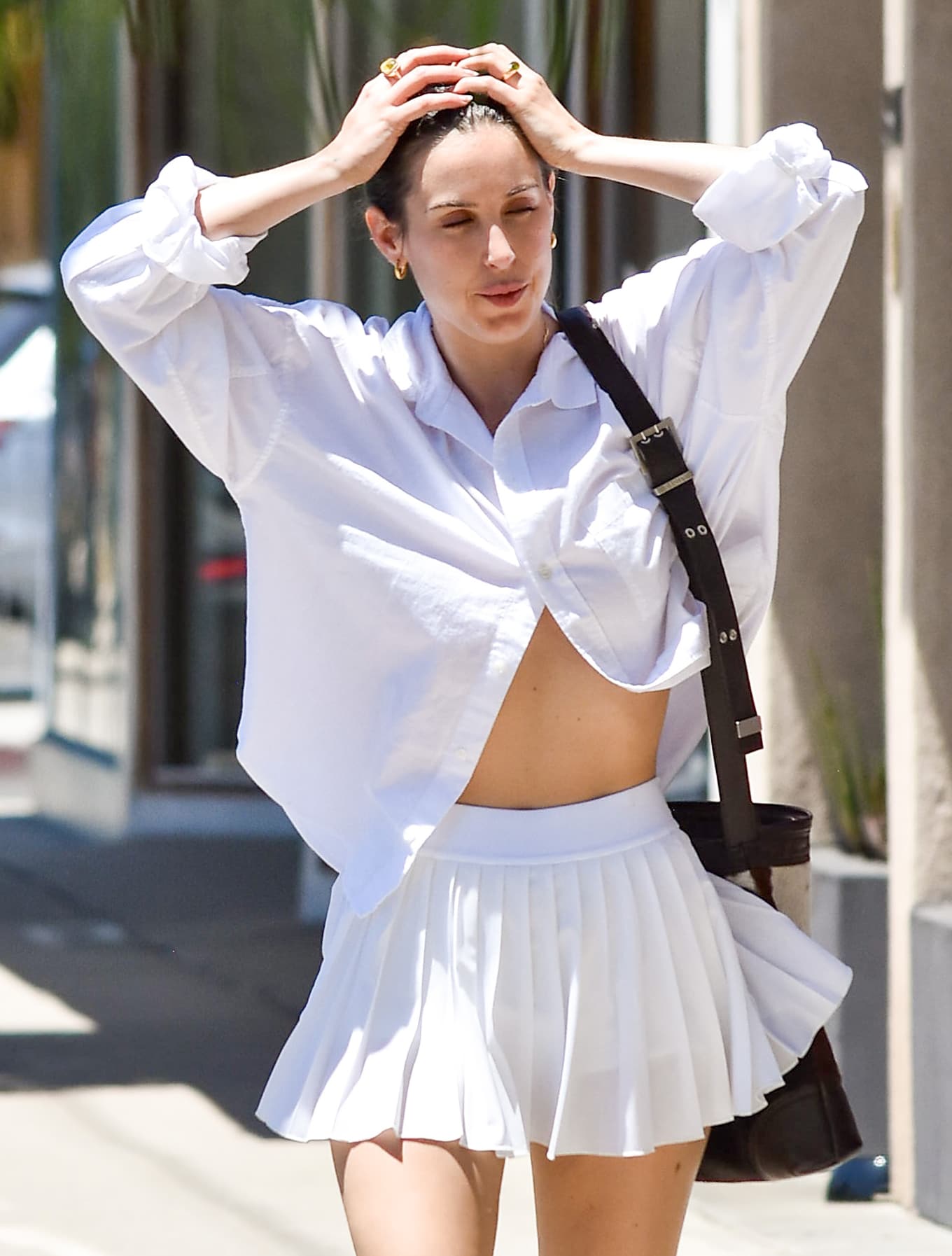 Scout Willis exudes effortless summer confidence in a crisp cropped white button-down and pleated mini skirt
