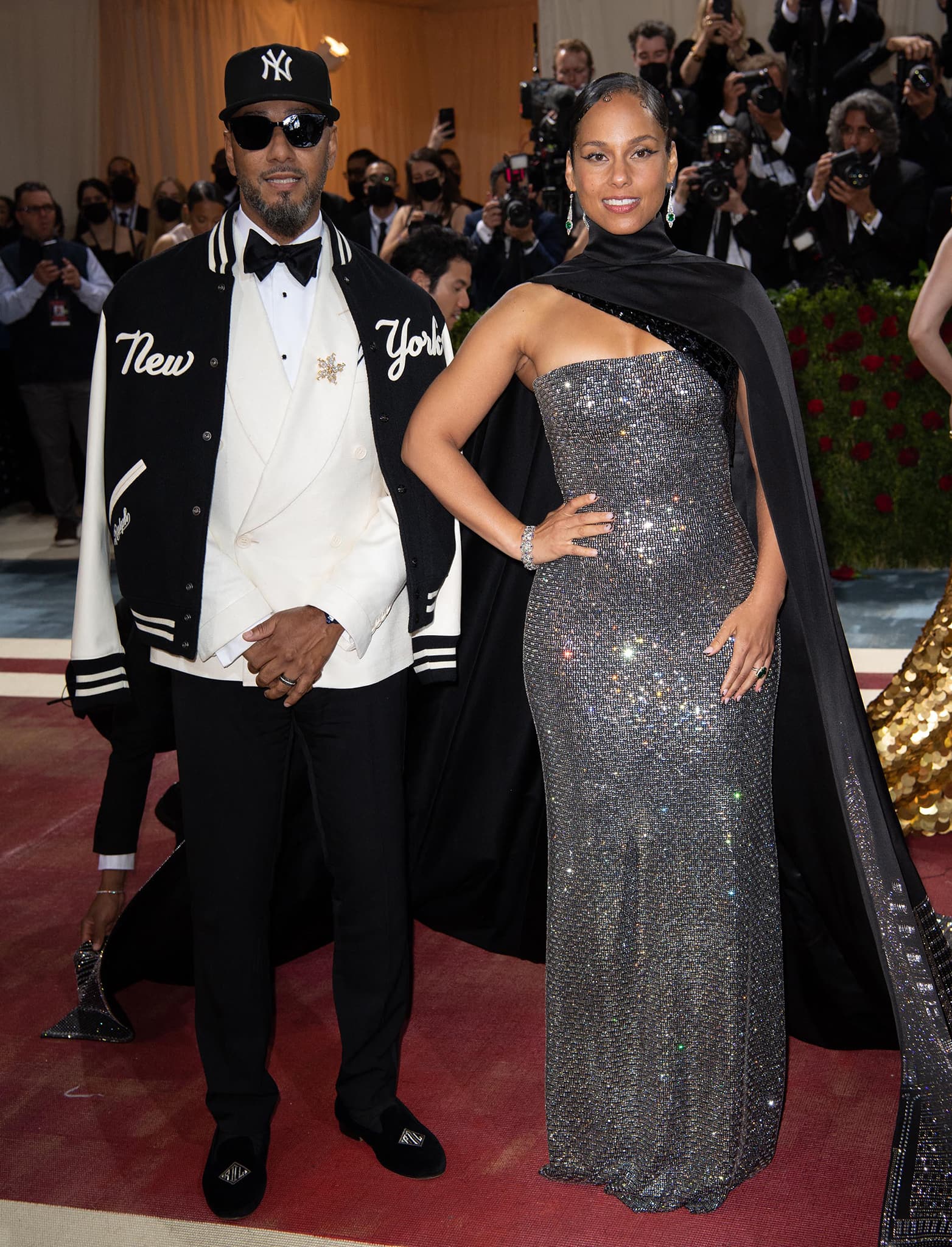 Alicia Keys and Swizz Beatz coordinate New York-inspired Ralph Lauren looks at the 2022 Met Gala, with Keys wearing a crystal-embellished gown and skyline cape while Swizz pairs a Yankees varsity jacket and white tuxedo with black velvet loafers