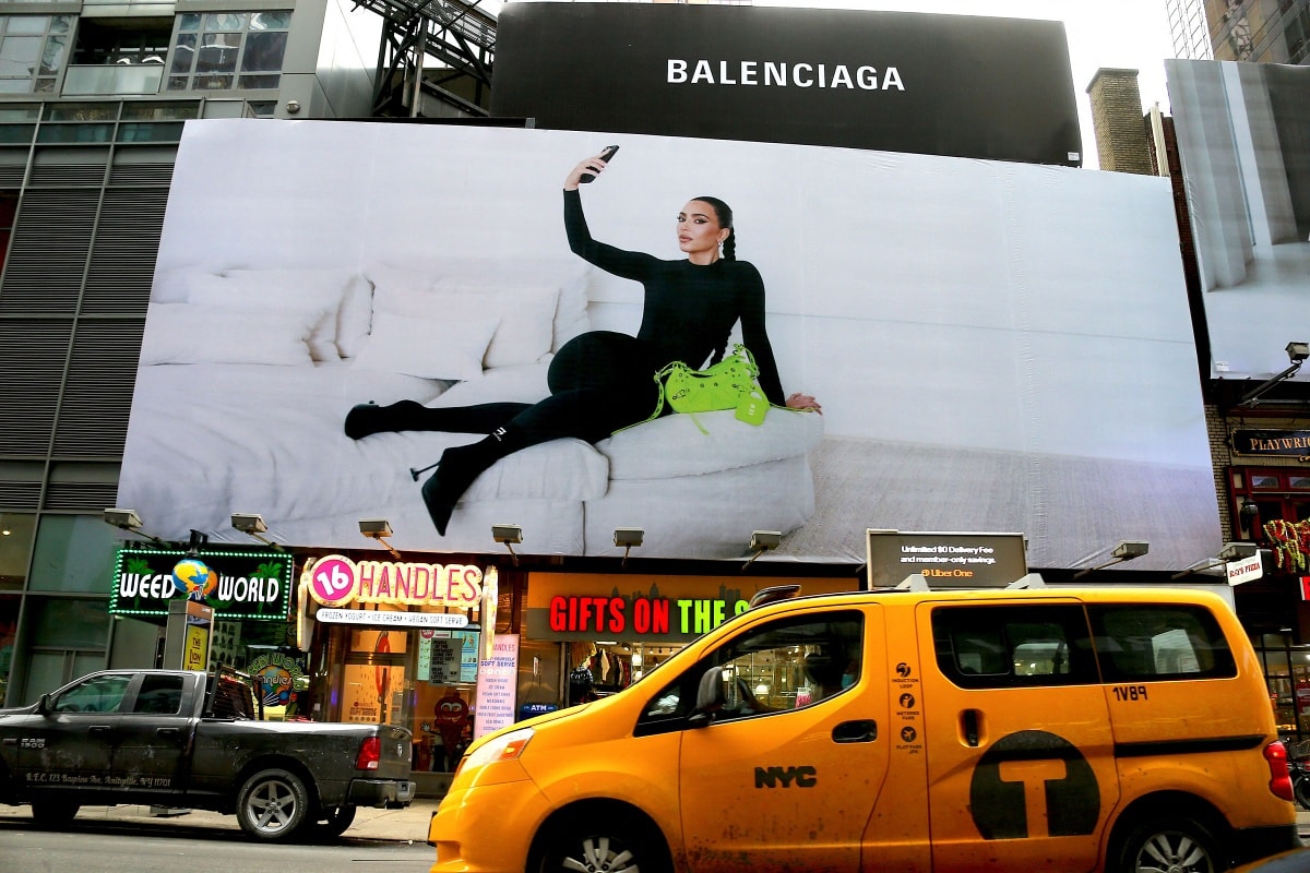 Kim Kardashian lounges in pointed-toe Balenciaga Knife boots on a massive Times Square billboard promoting the brand’s 2022 campaign