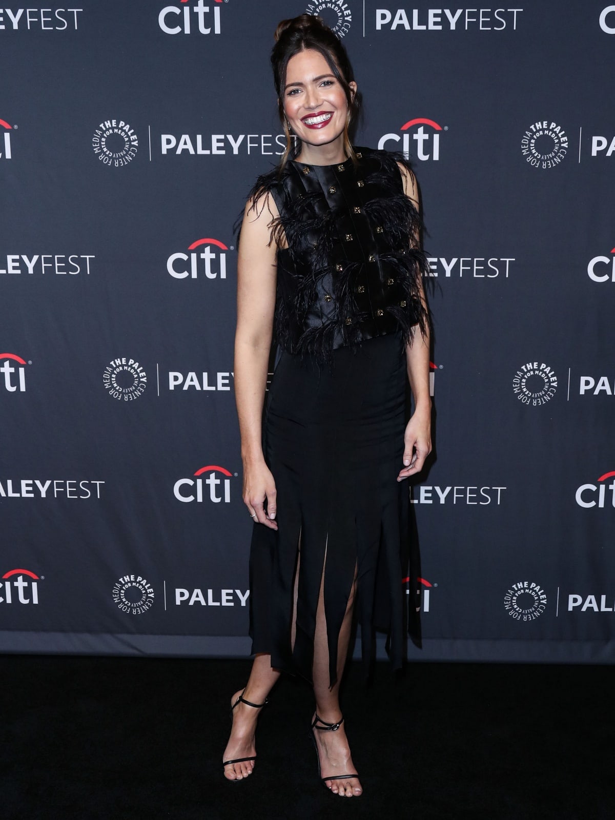 Mandy Moore wearing a feathered top and wide fringe skirt during the "This Is Us" presentation