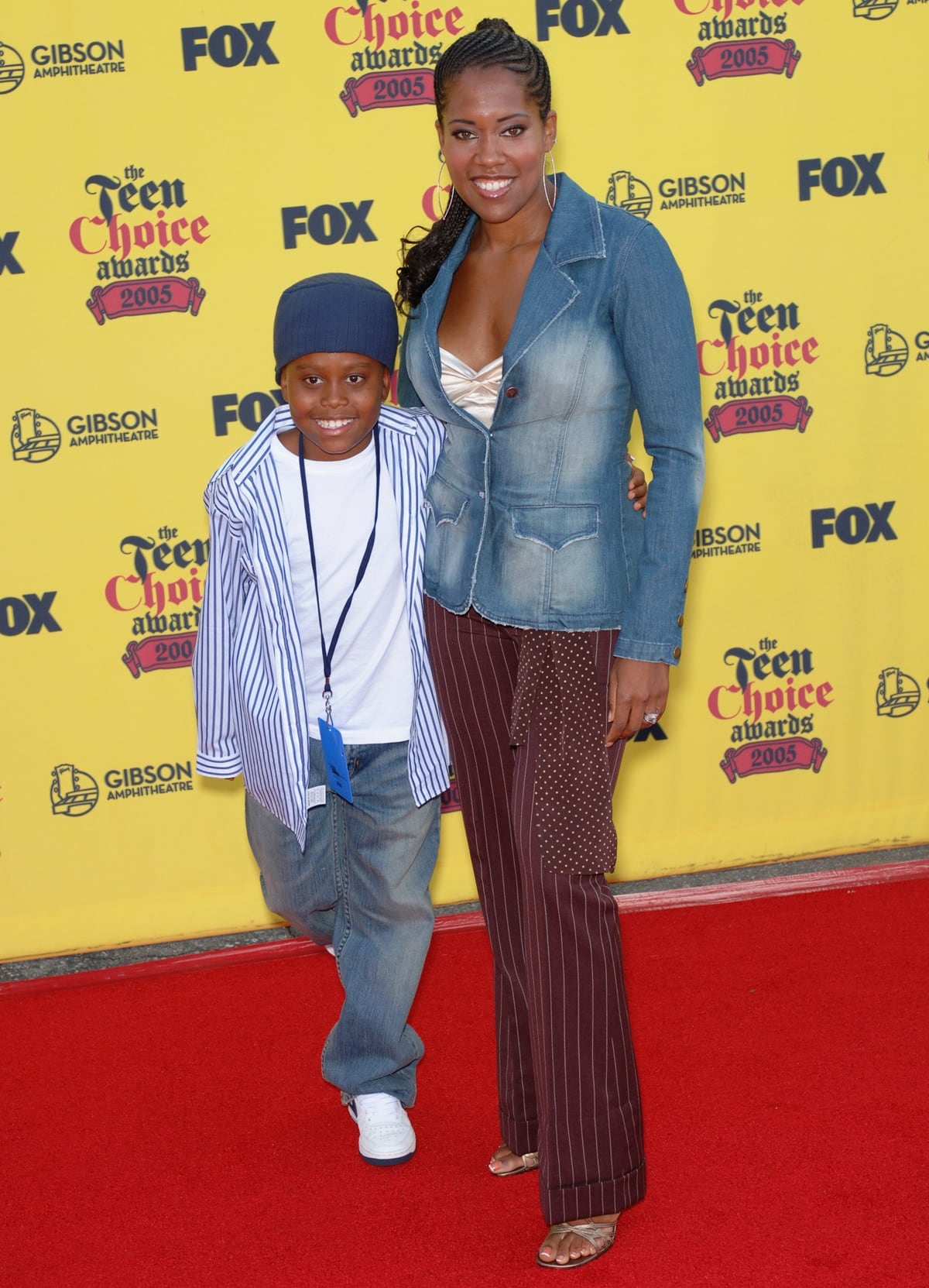 Actress Regina King, wearing a denim blazer layered over a champagne satin top with pinstriped trousers and metallic strappy sandals, arrives with her son Ian Alexander Jr. at the 2005 Teen Choice Awards at the Gibson Amphitheatre in Universal City, California