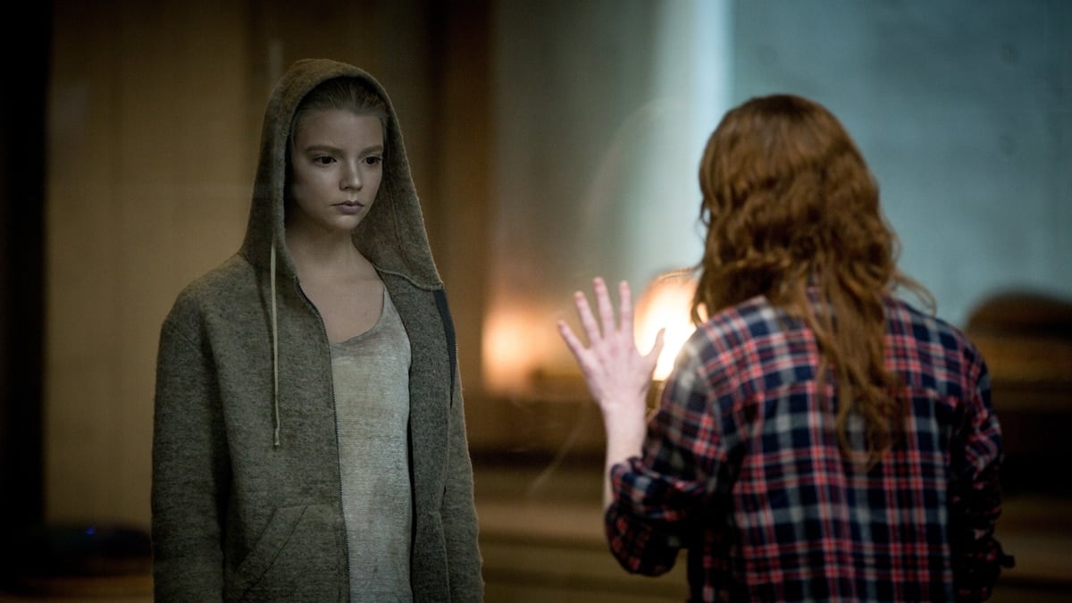 Anya Taylor-Joy embodies eerie minimalism as the genetically engineered Morgan, wearing a muted gray hoodie and simple tank top that underscore her character’s haunting detachment