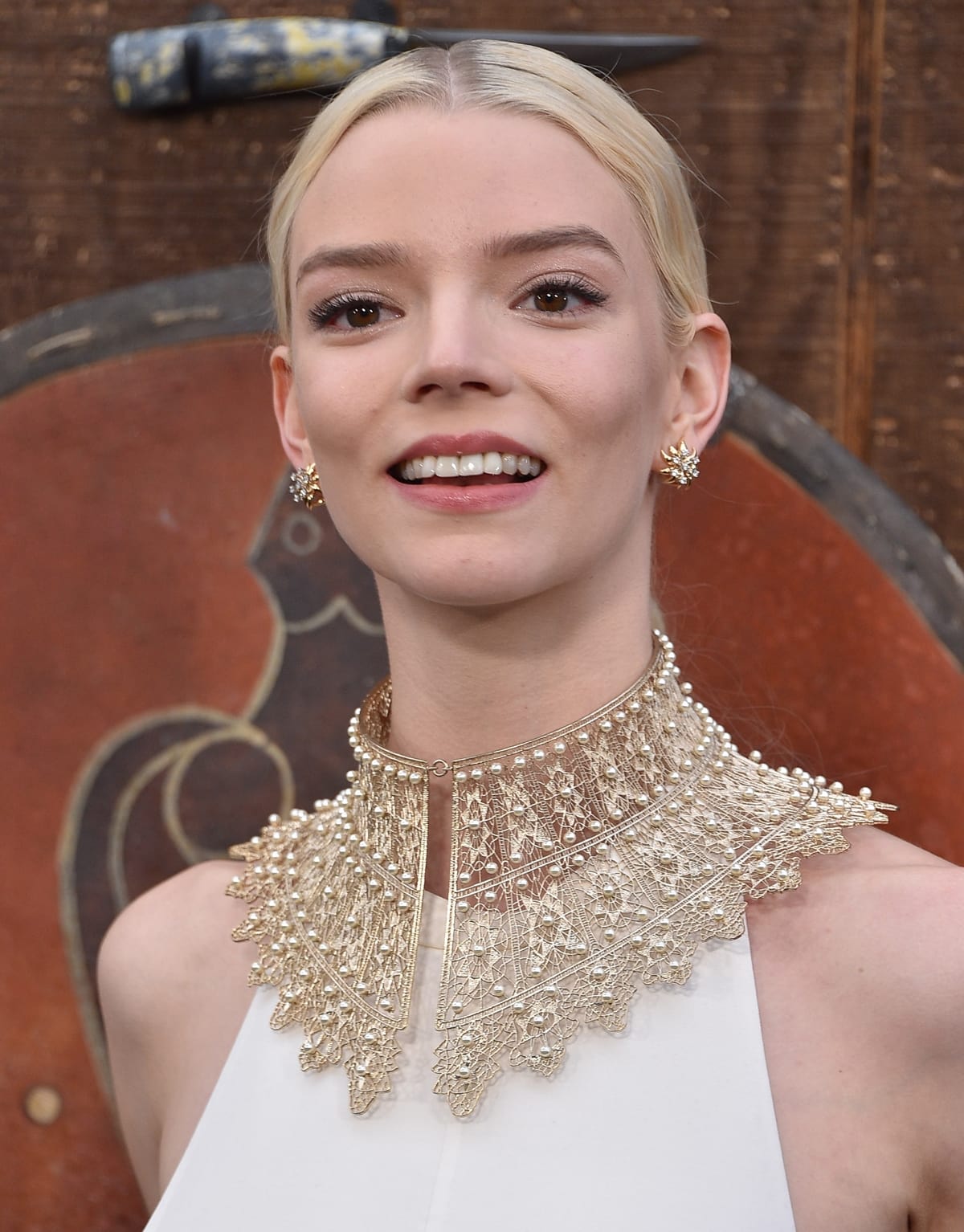Anya Taylor-Joy stuns in a dramatic embellished gold collar necklace and starburst earrings at The Northman premiere, exuding regal, Viking-inspired elegance