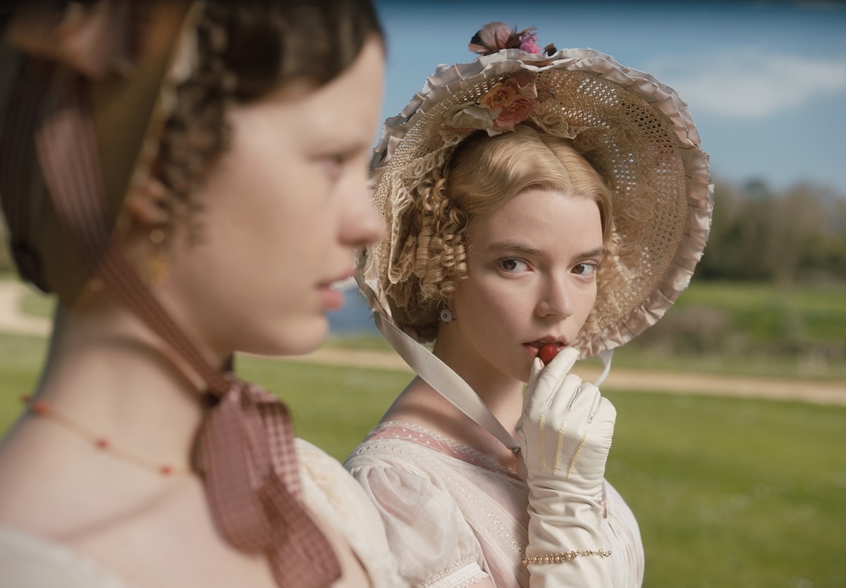 Anya Taylor-Joy oozes aristocratic charm in EMMA., wearing a blush embroidered gown, delicate gloves, and a floral-trimmed bonnet—capturing the refined yet mischievous spirit of Austen’s iconic heroine