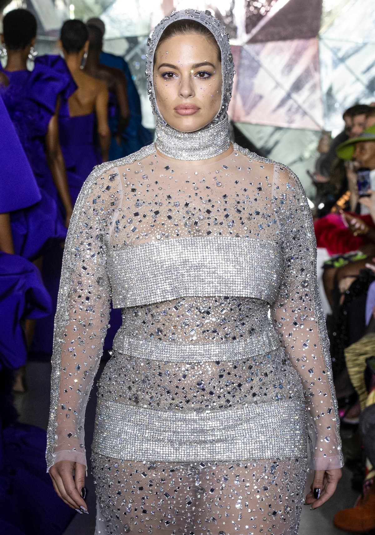 Ashley Graham dazzled on the runway in a futuristic, crystal-embellished sheer gown with a matching hood