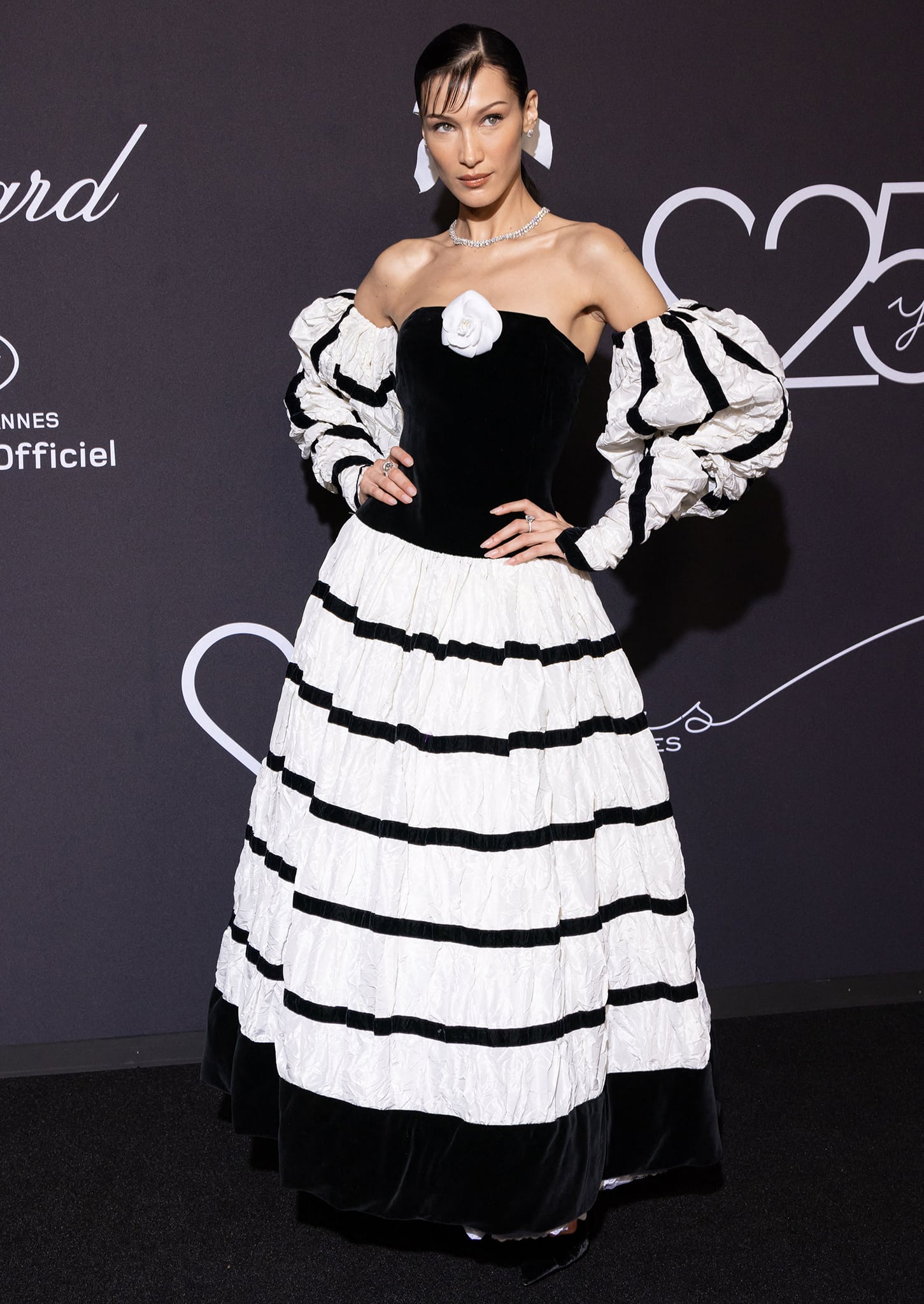 Bella Hadid channels vintage cabaret glamour in a dramatic black-and-white Chanel gown with voluminous mutton sleeves and ruffle detailing, styled with Chopard diamonds at the “Chopard Loves Cinema” gala at Hotel Martinez on May 25, 2022