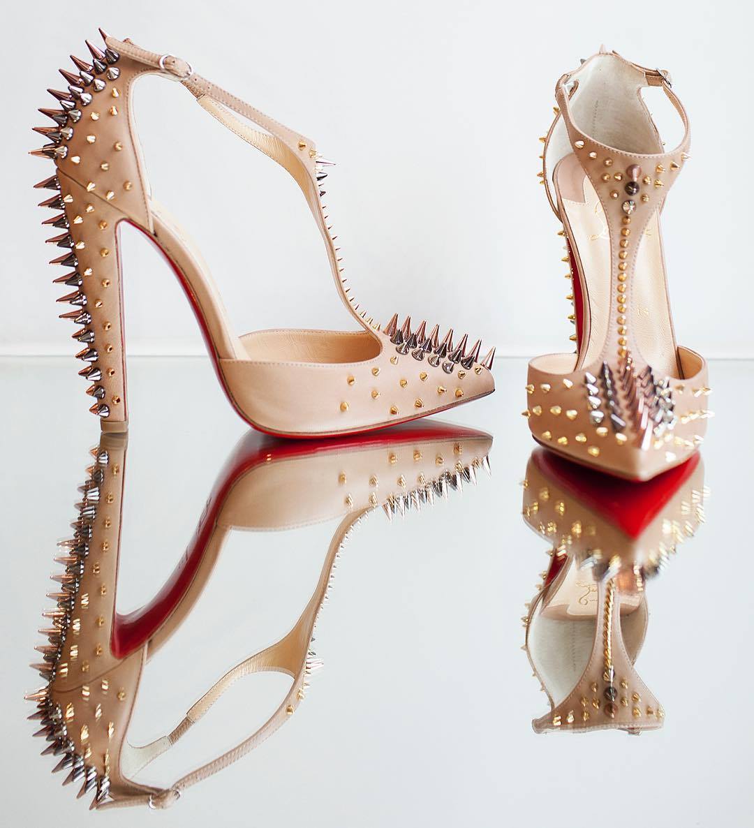 Christian Louboutin’s “Goldostrap” pumps stun in nude Nappa leather, covered in mixed-metal spikes that trace the T-strap, toe, and heel for a fierce, sculptural finish