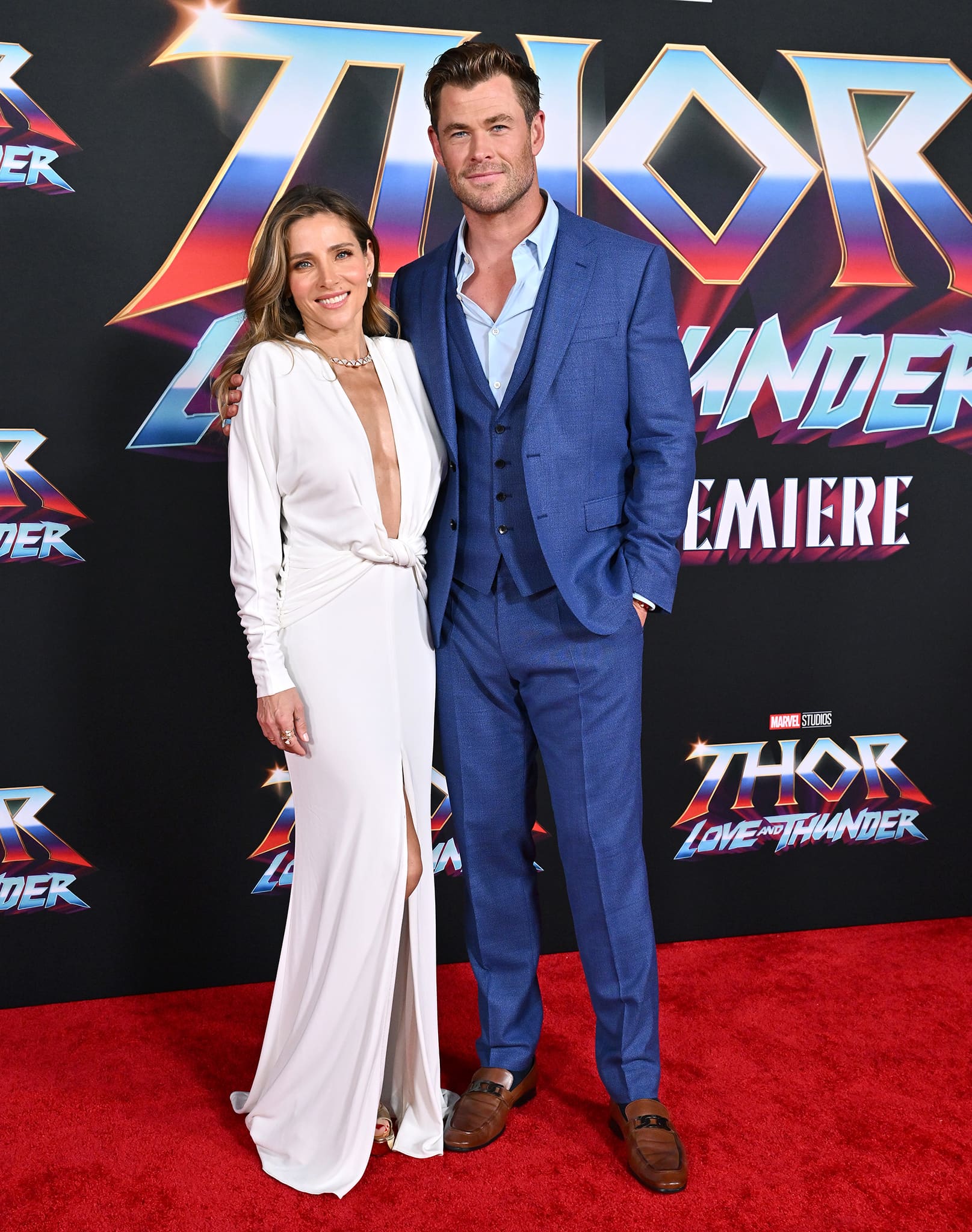 Elsa Pataky stuns in a plunging white gown paired with metallic platform heels as she joins Chris Hemsworth on the Thor: Love and Thunder red carpet