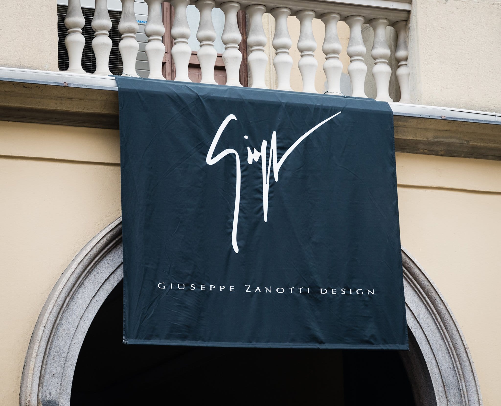 A Giuseppe Zanotti Design banner proudly hangs outside, featuring the brand's signature logo that represents luxury, innovation, and Italian craftsmanship in footwear