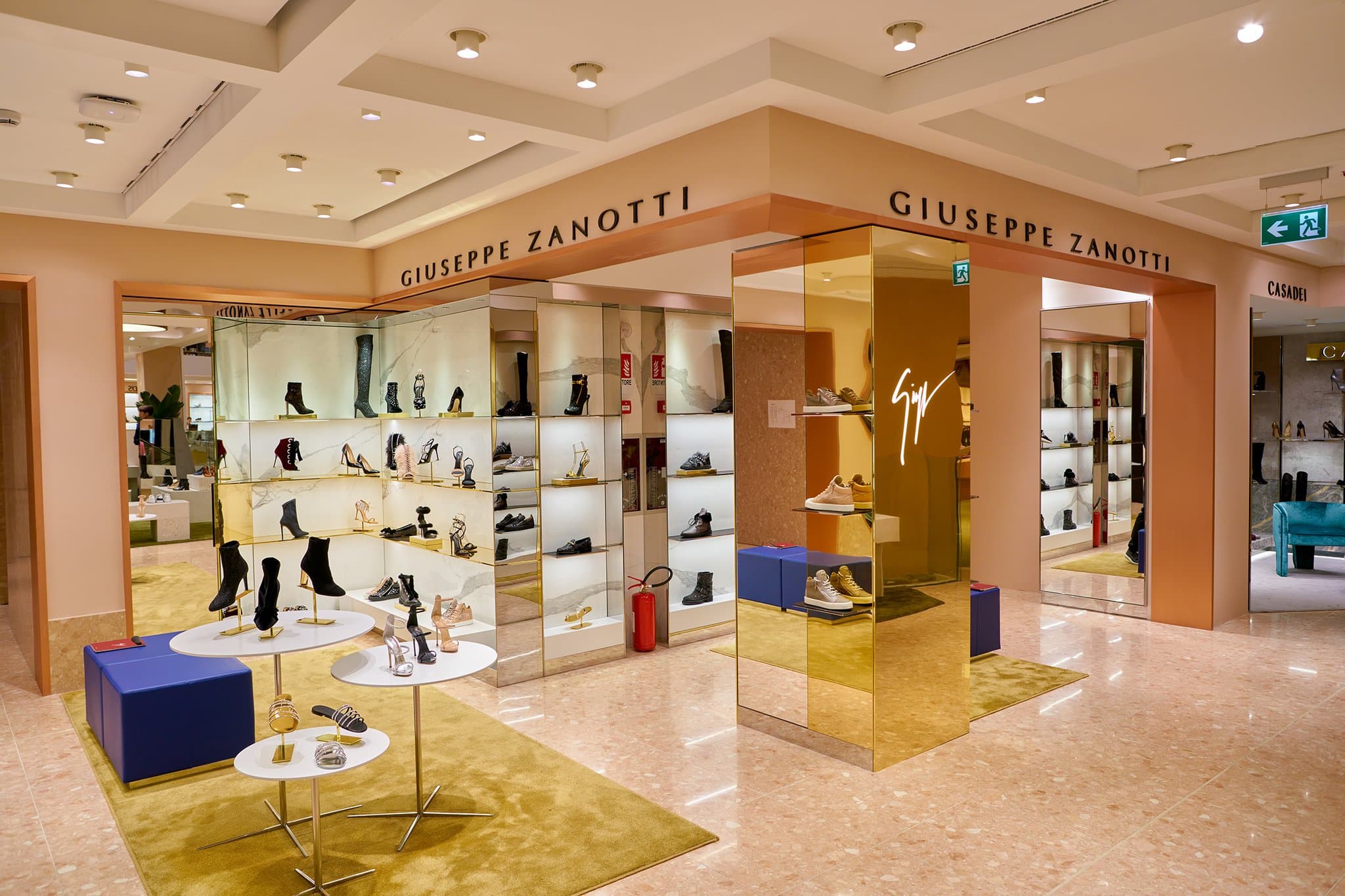 The Giuseppe Zanotti boutique showcases an elegant display of the brand's signature luxury footwear, blending modern aesthetics with gold accents to highlight its timeless Italian craftsmanship