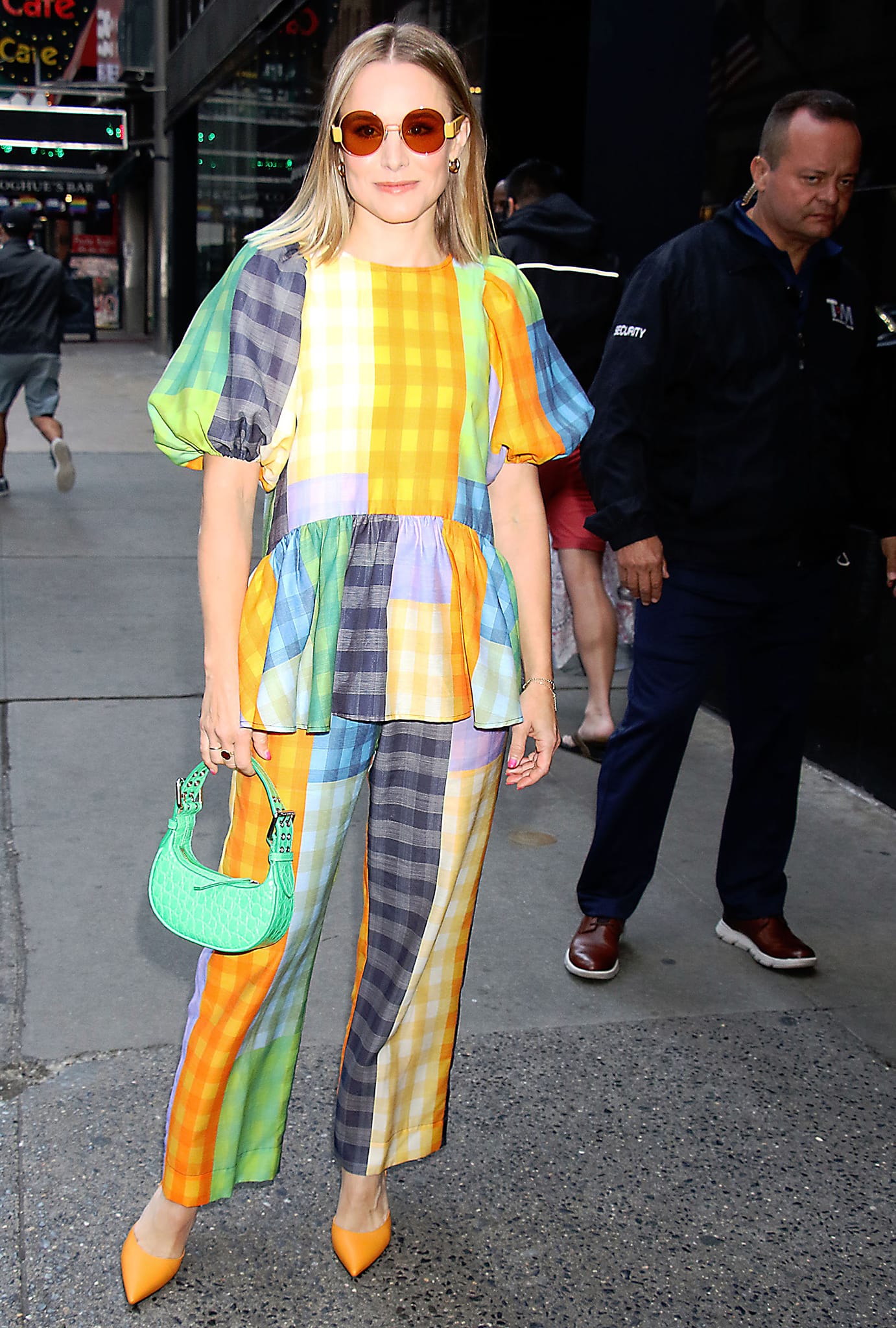Kristen Bell lets her orange pointed-toe pumps echo the warm tones of her multicolored gingham ensemble while stepping out at the Good Morning America studios