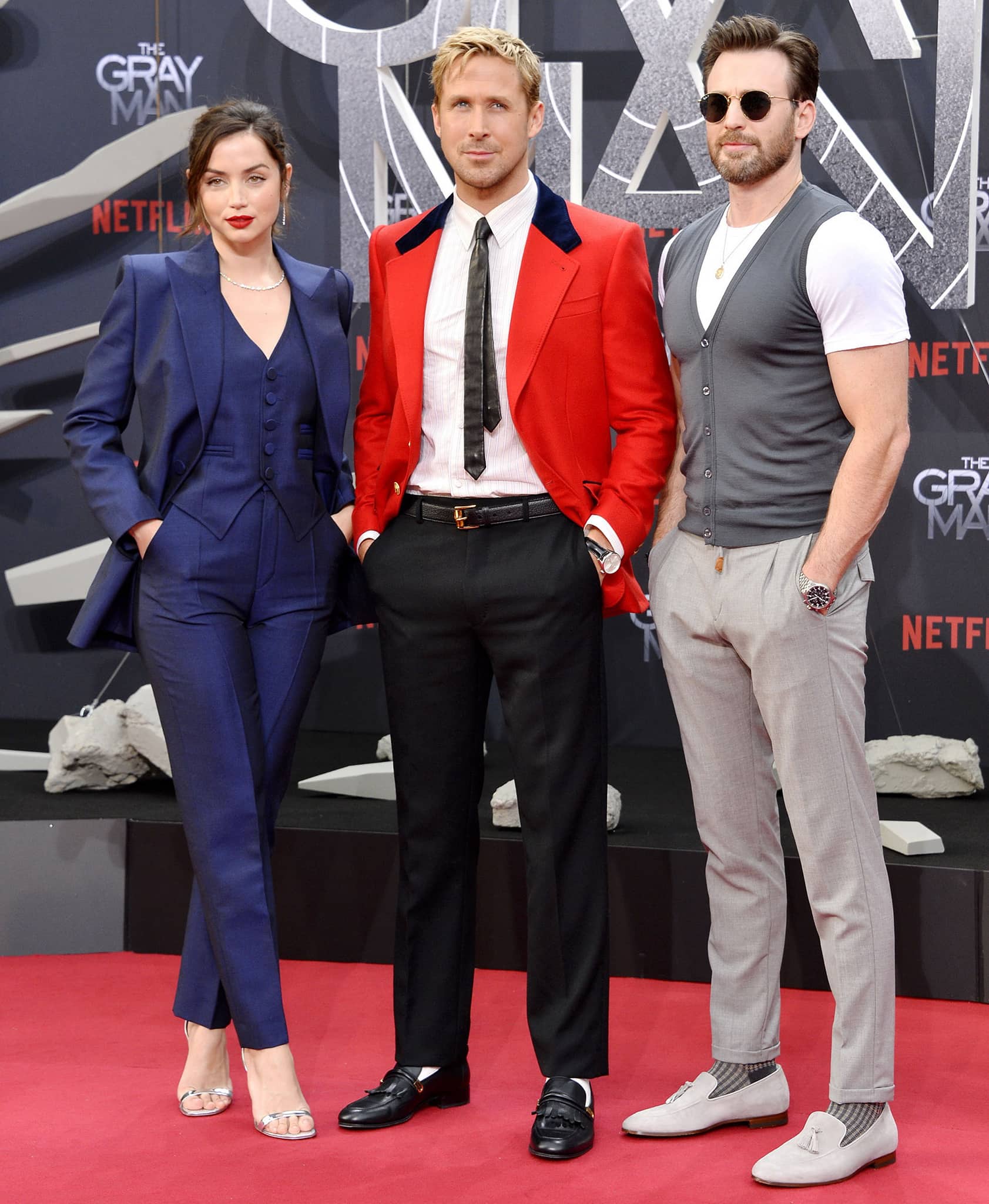 Ana de Armas, Ryan Gosling, and Chris Evans contrast silver sandals, Gucci horsebit heeled loafers, and tasseled loafers on The Gray Man Berlin red carpet