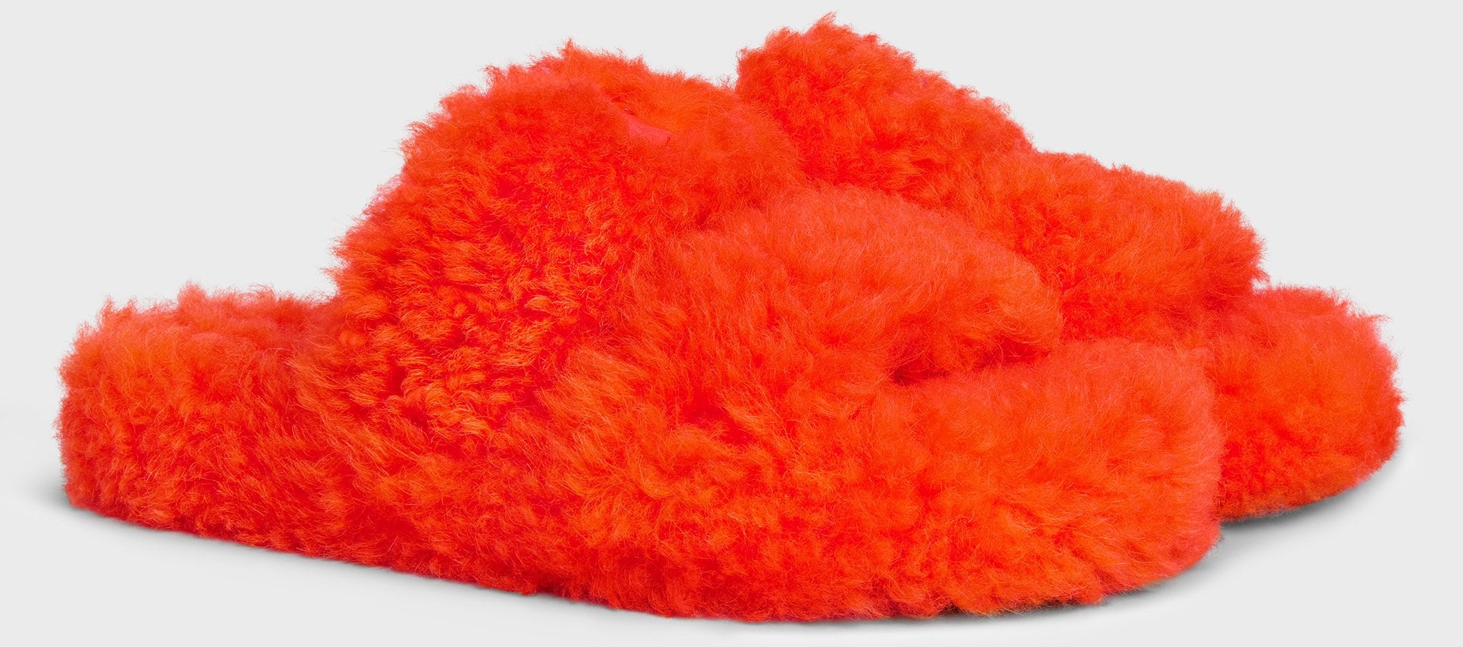 Splurge on these Celine fluffy slides made of 100% shearling with the Triomphe signature leather patch on the upper