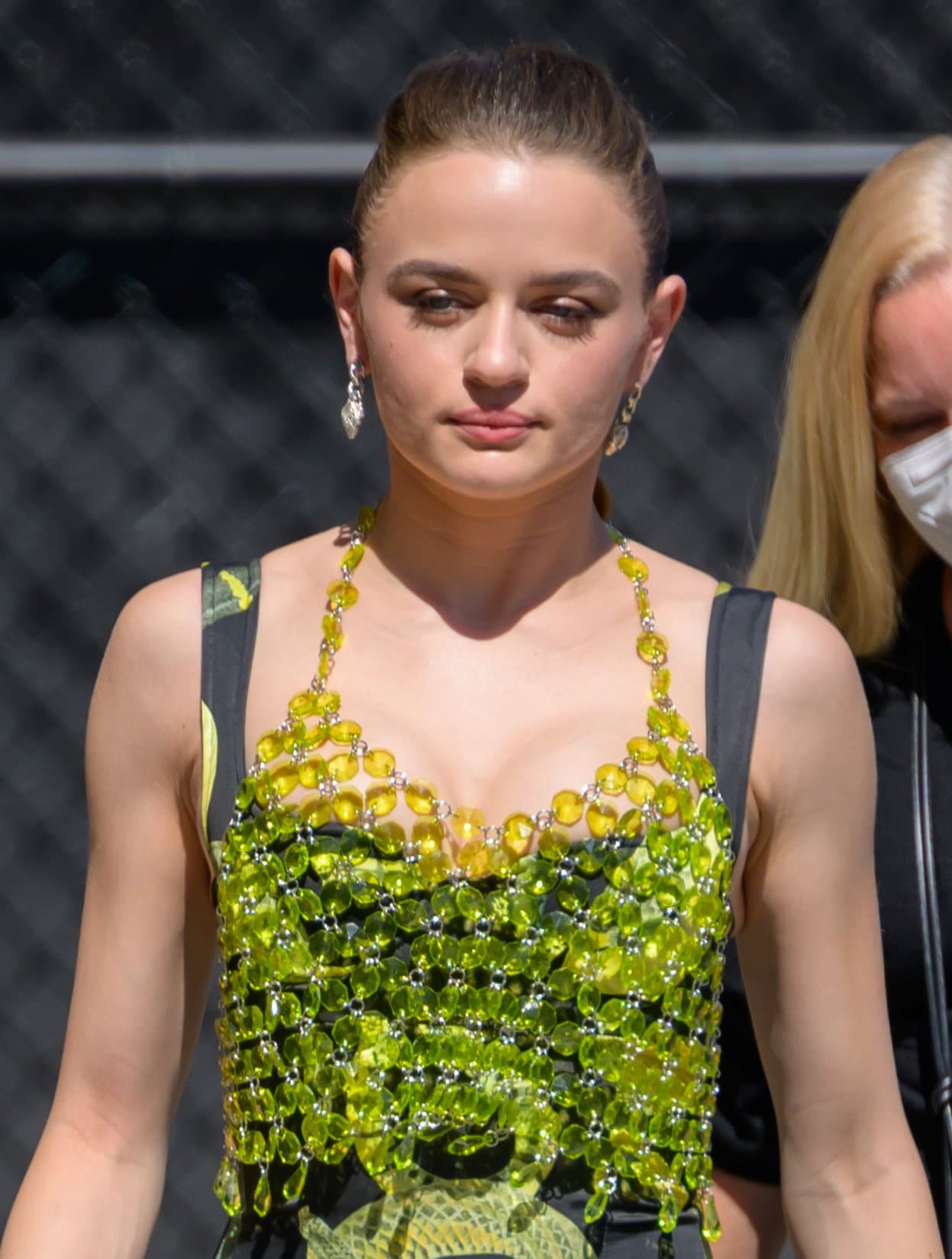 Joey King highlights her look with a crystal-embellished Akira halter layered over a Milkwhite snake-print dress, finished with sparkling drop earrings for added glamour