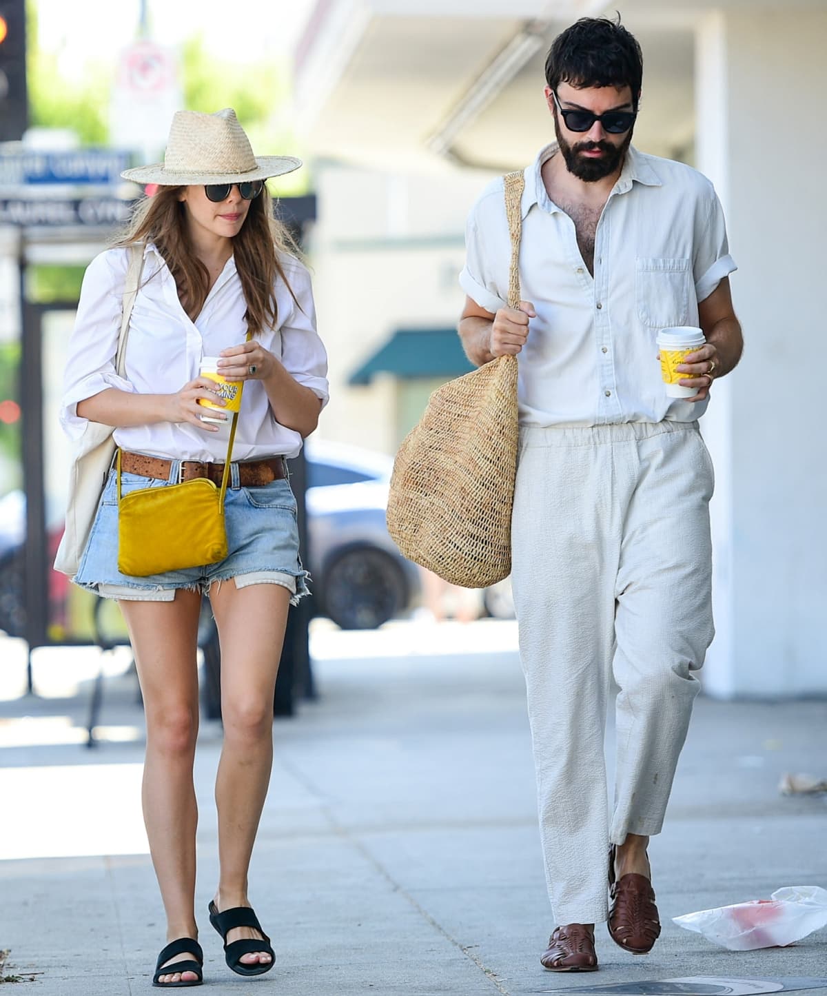 For her date with Robbie Arnett, Elizabeth Olsen wore Aquatalia Abbey wedge slide sandals with a white button-down shirt, Levi’s 501 Daisy Dukes, and Garrett Leight sunglasses