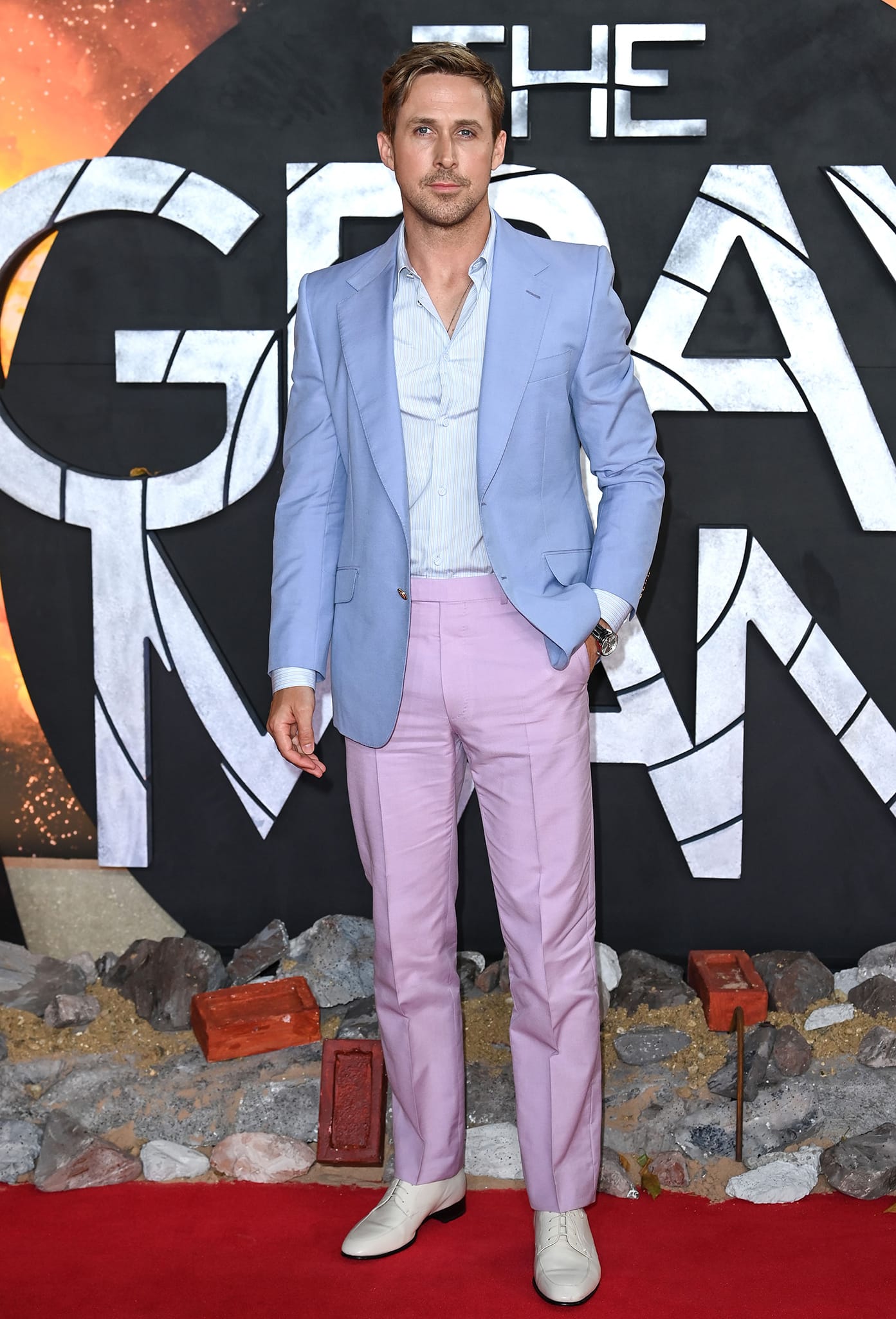Ryan Gosling gives classic tailoring a pastel twist in a lilac-blue Gucci jacket, pink trousers, and crisp white leather oxfords at The Gray Man London premiere