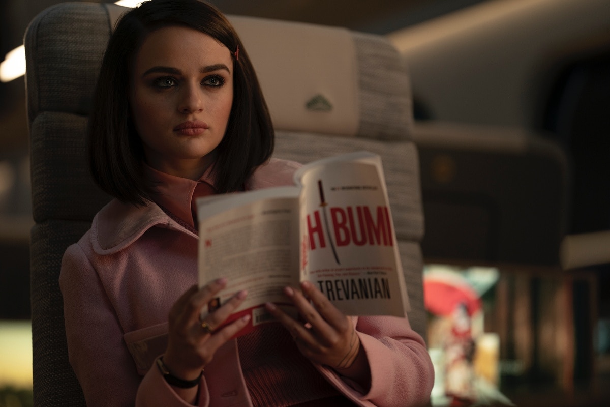 Joey King channels her character The Prince, a poised yet deadly assassin, in a scene from Bullet Train where she’s seen reading Shibumi by Trevanian