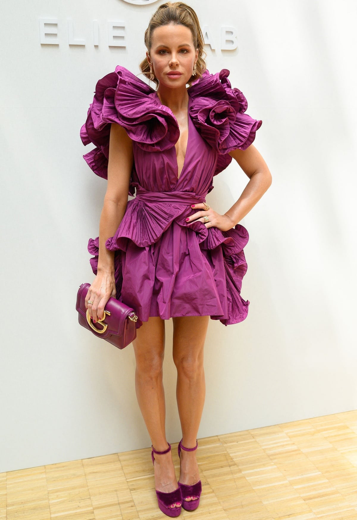 Kate Beckinsale makes a bold statement in a sculptural purple Elie Saab Fall 2022 minidress, paired with matching velvet ankle-strap platform heels at the Haute Couture show on July 6, 2022