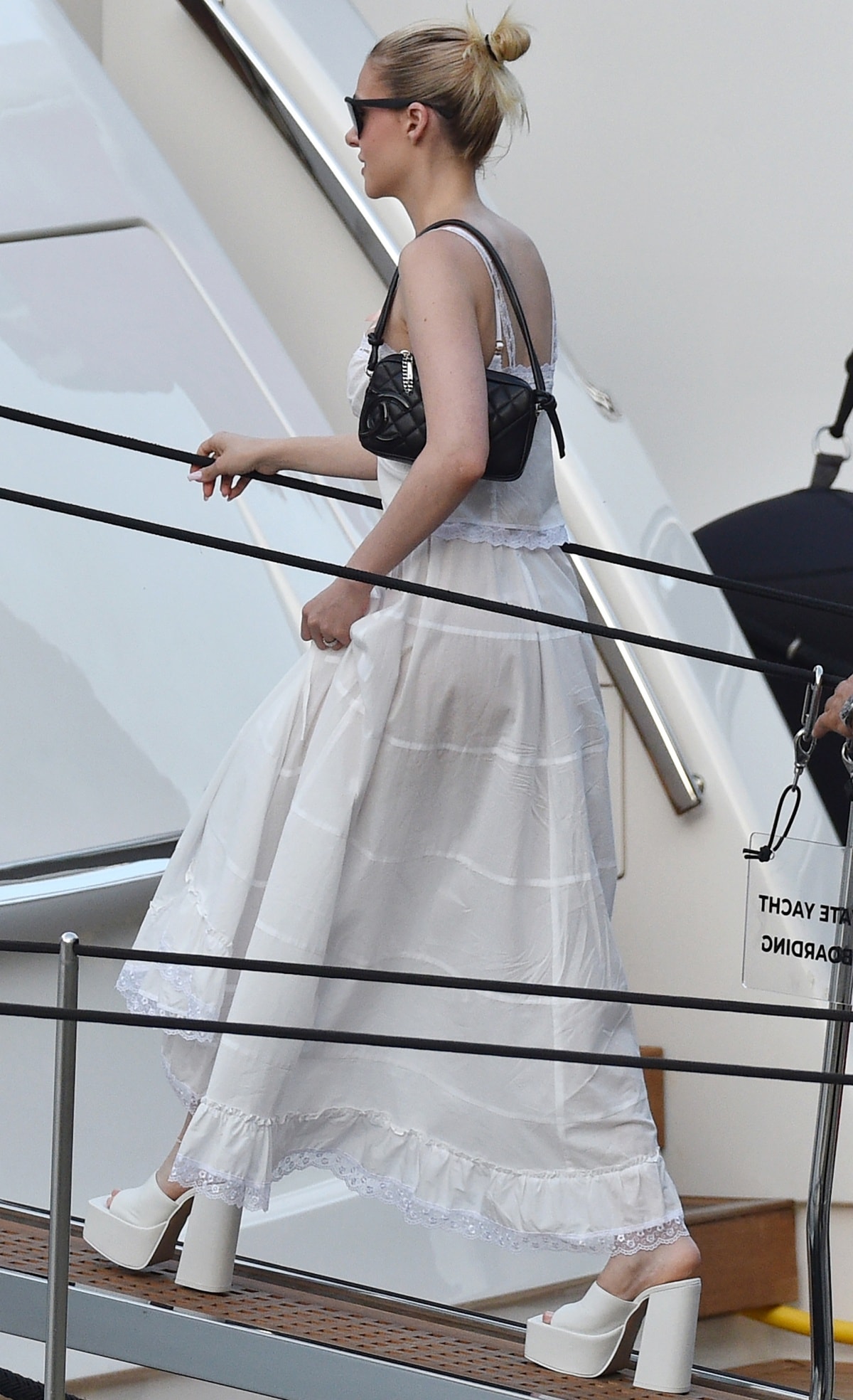 Nicola Peltz, who stands 5ft 5½ (166.4 cm) and wears a US size 7.5, gains a dramatic height boost from her towering white Steve Madden Trixie platform mules, which elevate her flowing Portofino look while adding striking presence with their chunky platform and block heel