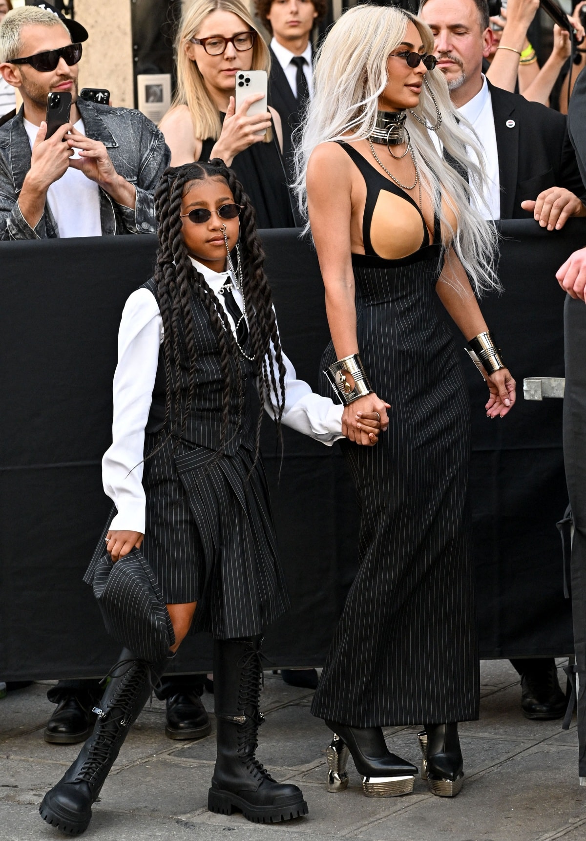 North West and Kim Kardashian make a striking entrance at the Jean Paul Gaultier x Olivier Rousteing couture show, coordinating in pinstriped looks finished with bold, statement-making footwear