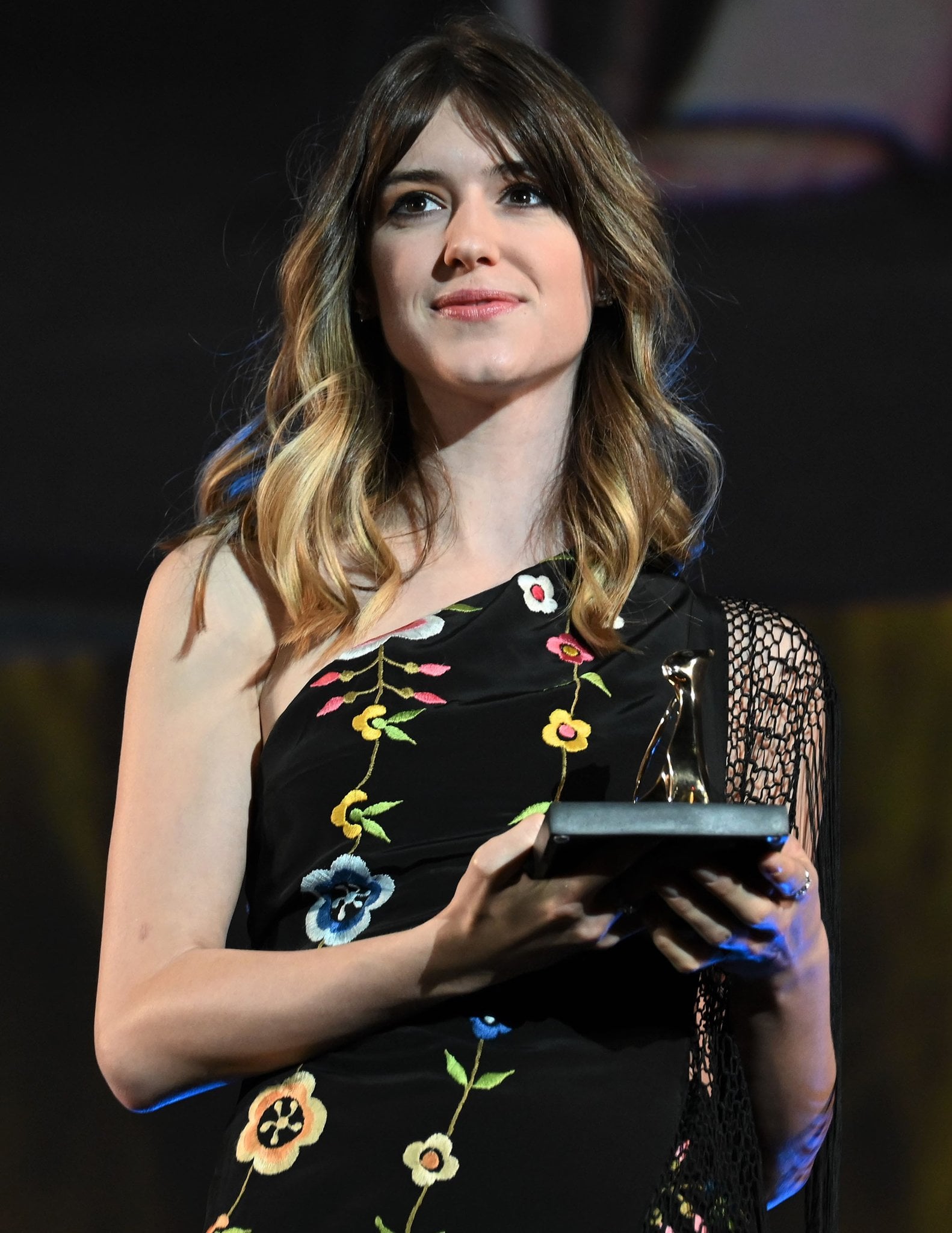 Daisy Edgar-Jones styles her tresses down in loose waves and glams up with eyeliner, mascara, and pink lipstick