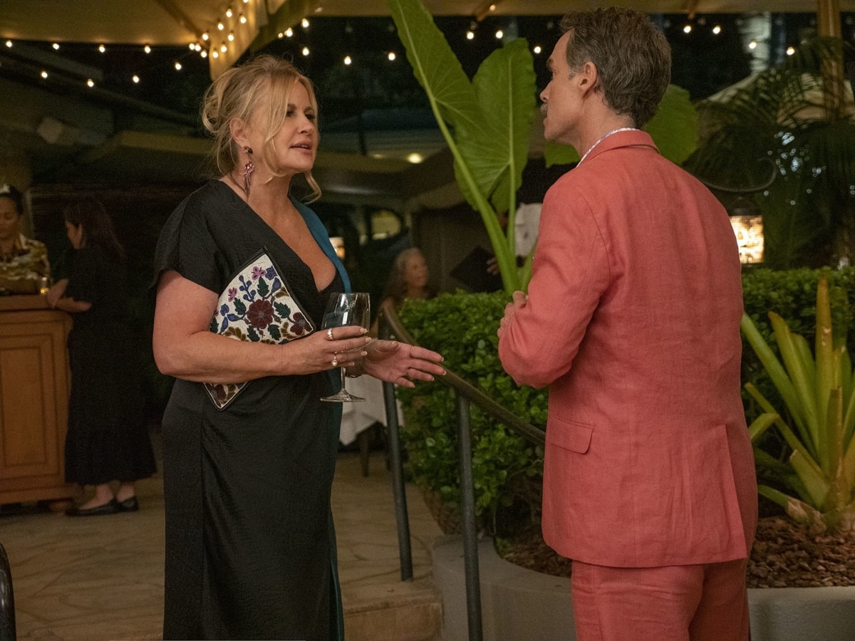 Jennifer Coolidge, as Tanya McQuoid in The White Lotus, stuns in a plunging black evening gown with an embroidered clutch while sharing a scene with Murray Bartlett’s Armond in the hit HBO dramedy