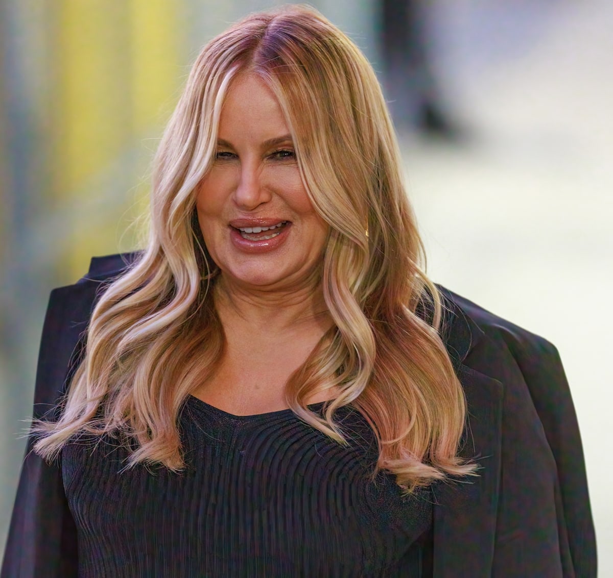 Jennifer Coolidge radiates confidence in a ribbed black top layered under a sleek black blazer