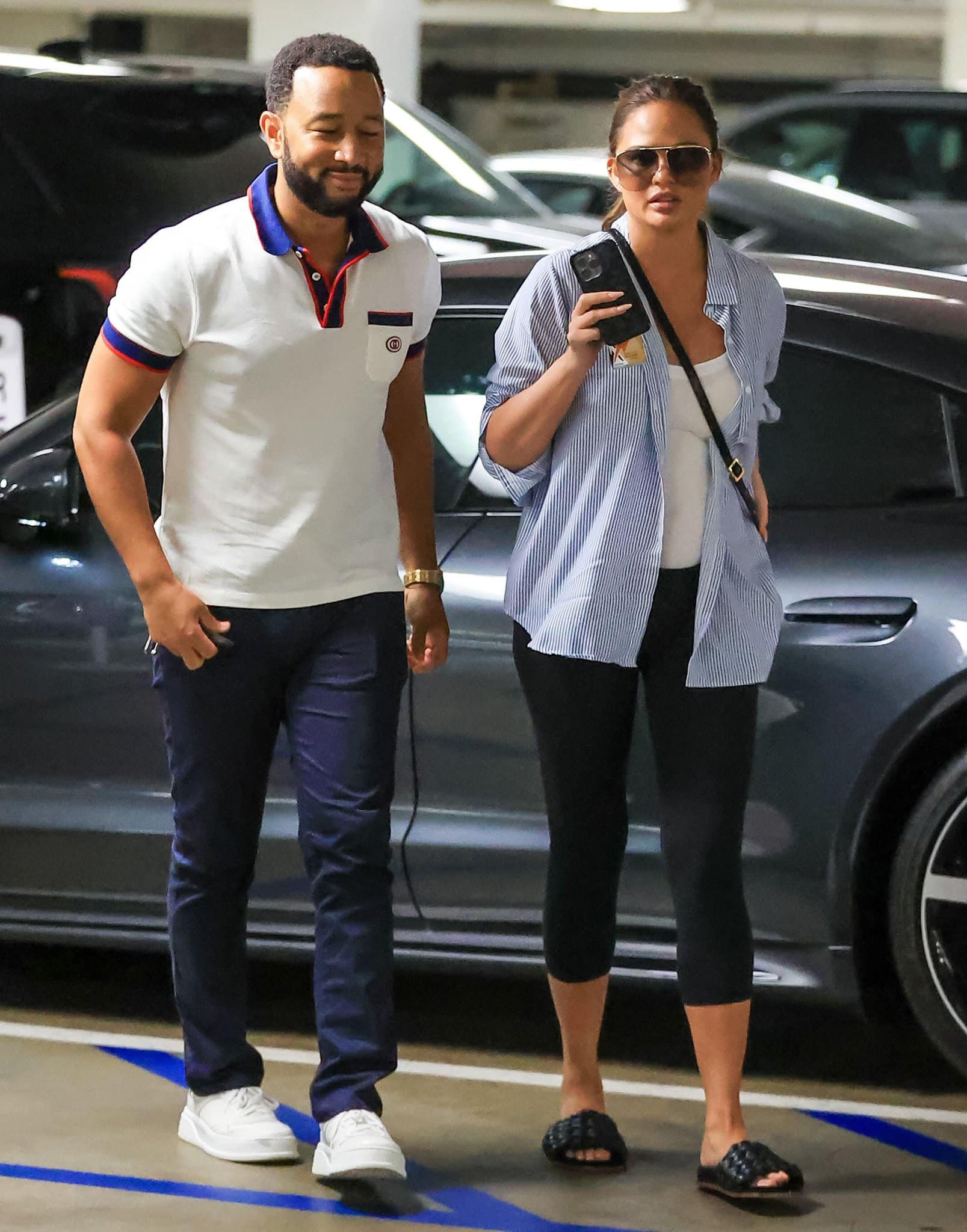 John Legend and Chrissy Teigen keep things relaxed in coordinated off-duty looks, with Teigen grounding her maternity outfit in black Chloé Kacey woven leather slide sandals while heading to an appointment in Los Angeles