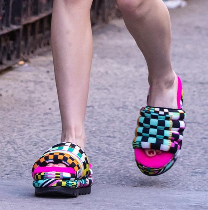 Kiernan Shipka pairs her black and pink outfit with multicolored UGG Maxi Checks slides