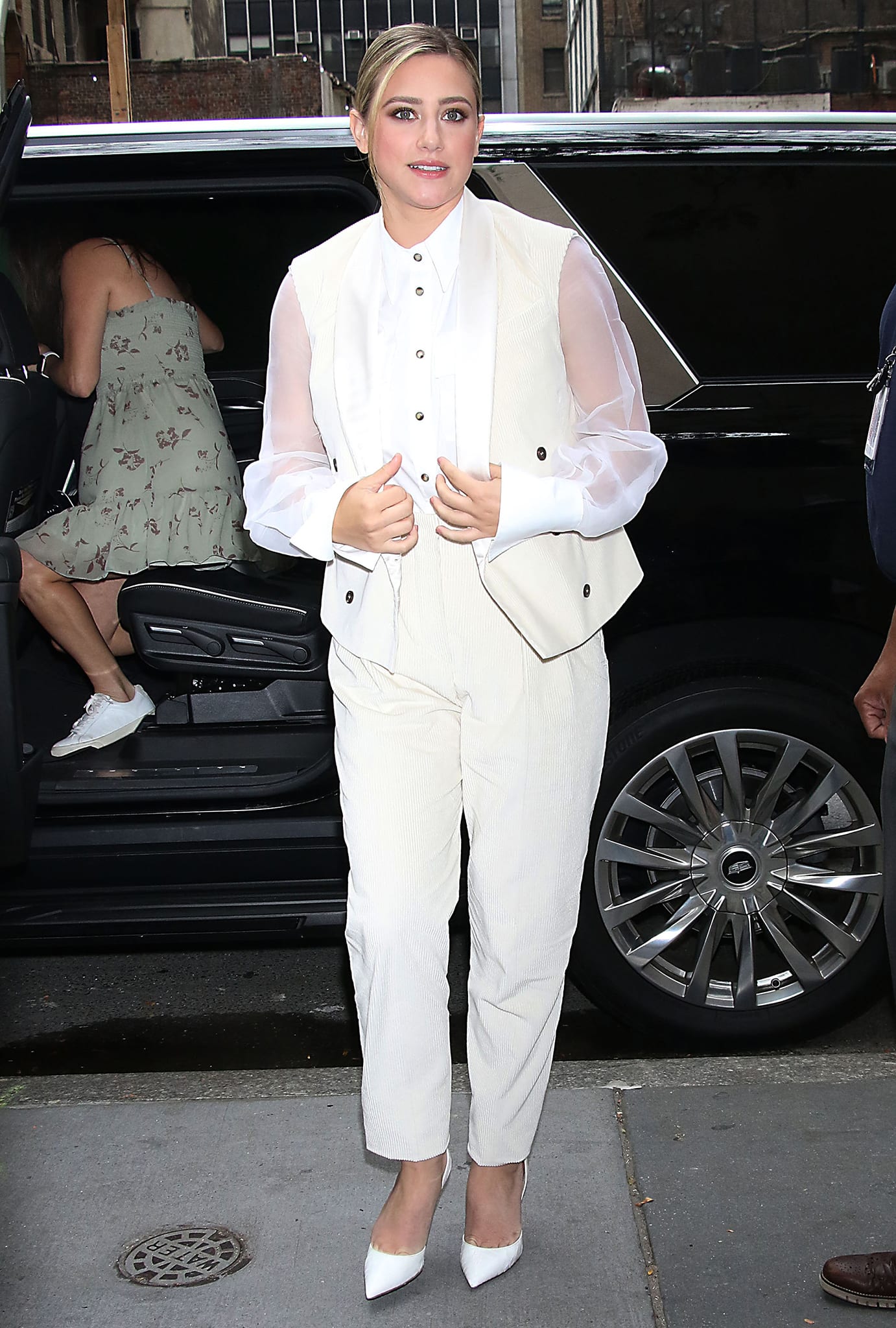 Lili Reinhart arrives at Good Morning America on August 10, 2022, elevating her cream corduroy suiting with sheer sleeves and crisp white pointed-toe pumps while promoting her Netflix film Look Both Ways