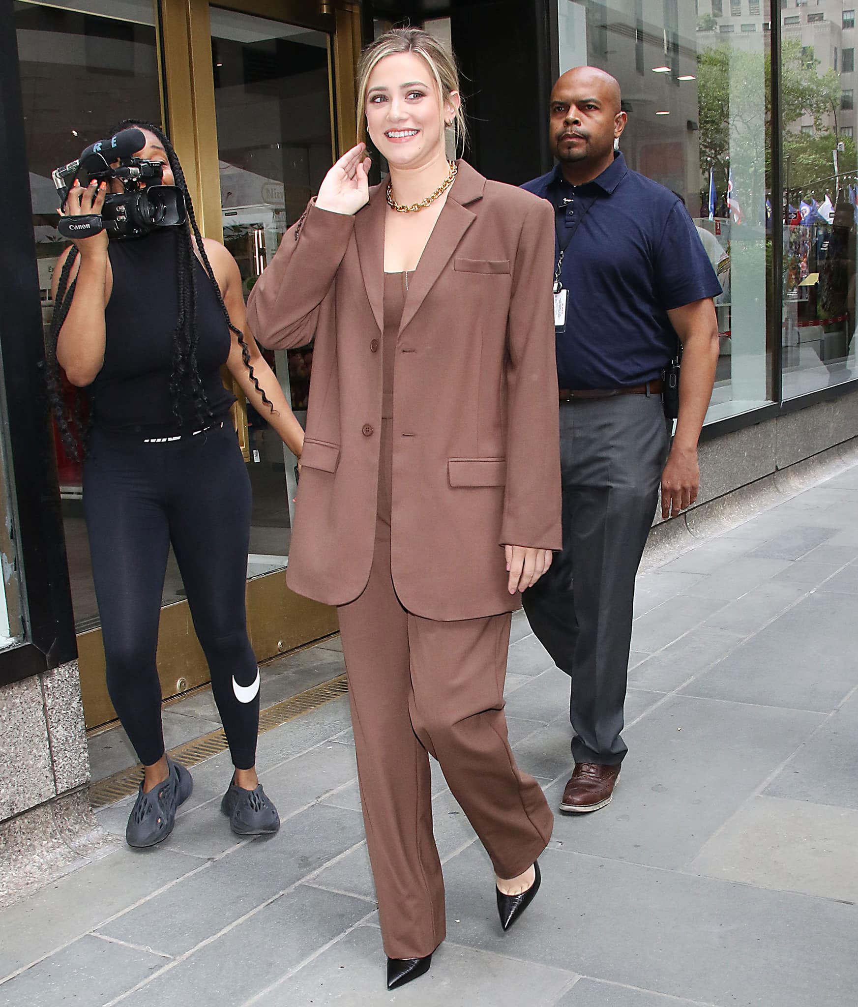 Lili Reinhart steps out for the Today Show in a chocolate brown Sir The Label suit, finishing the tailored look with black croc-effect Christian Louboutin Pigalle Follies pumps
