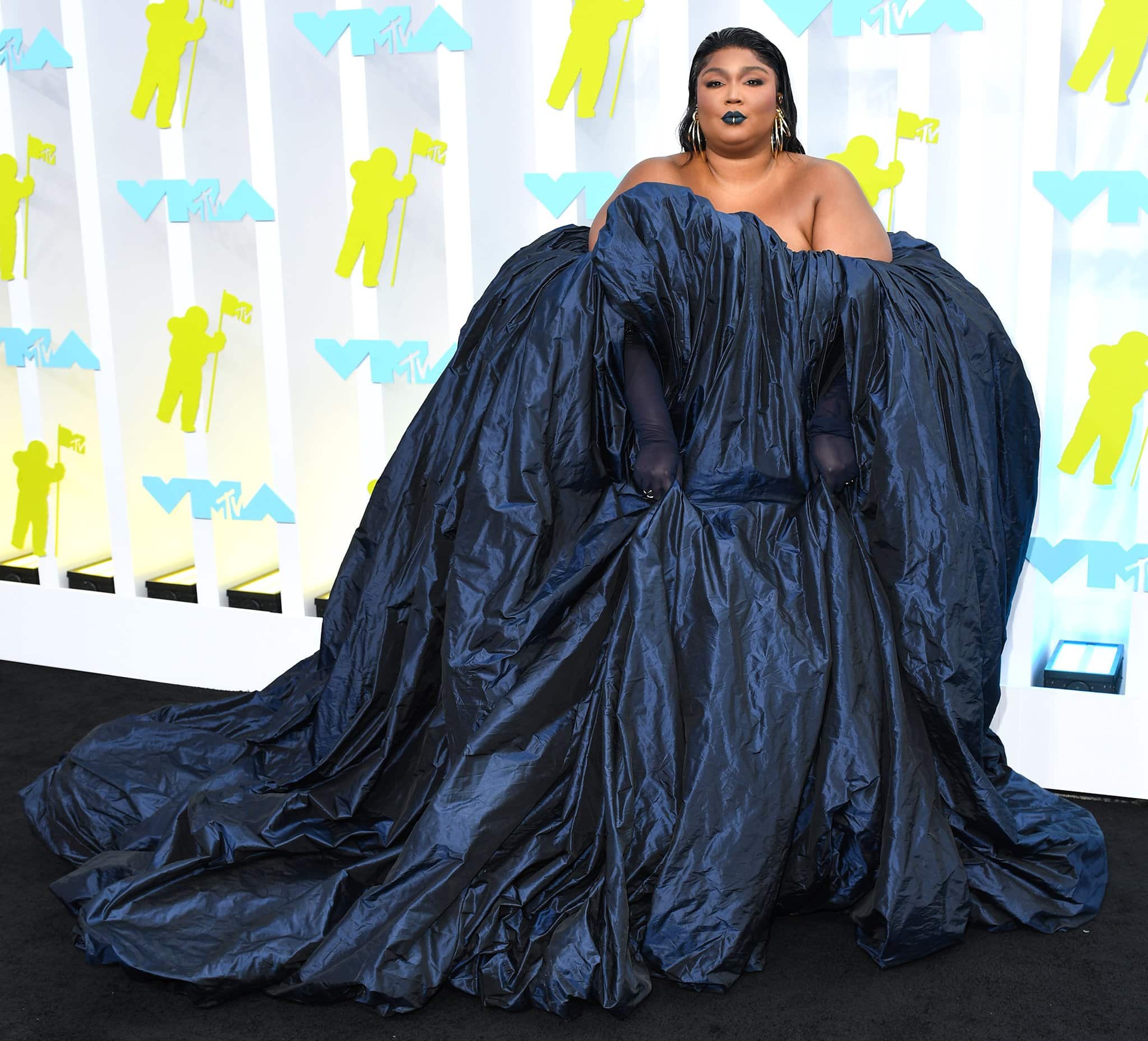Lizzo arrives on the red carpet in a voluminous iridescent navy gown by Glenn Martens for Jean Paul Gaultier’s Spring/Summer 2022 Couture collection