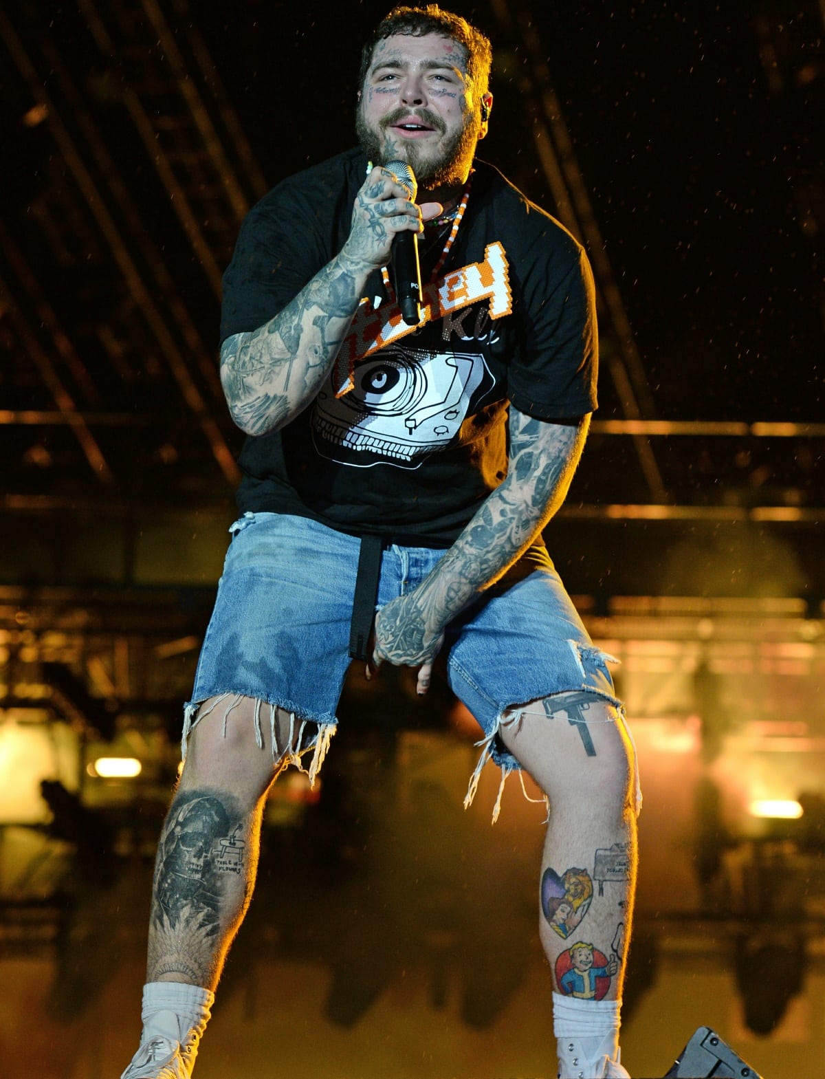 Post Malone hits the stage in distressed denim shorts, a graphic tee, and classic white sneakers while performing at the Rolling Loud Music Festival in Miami on July 24, 2021