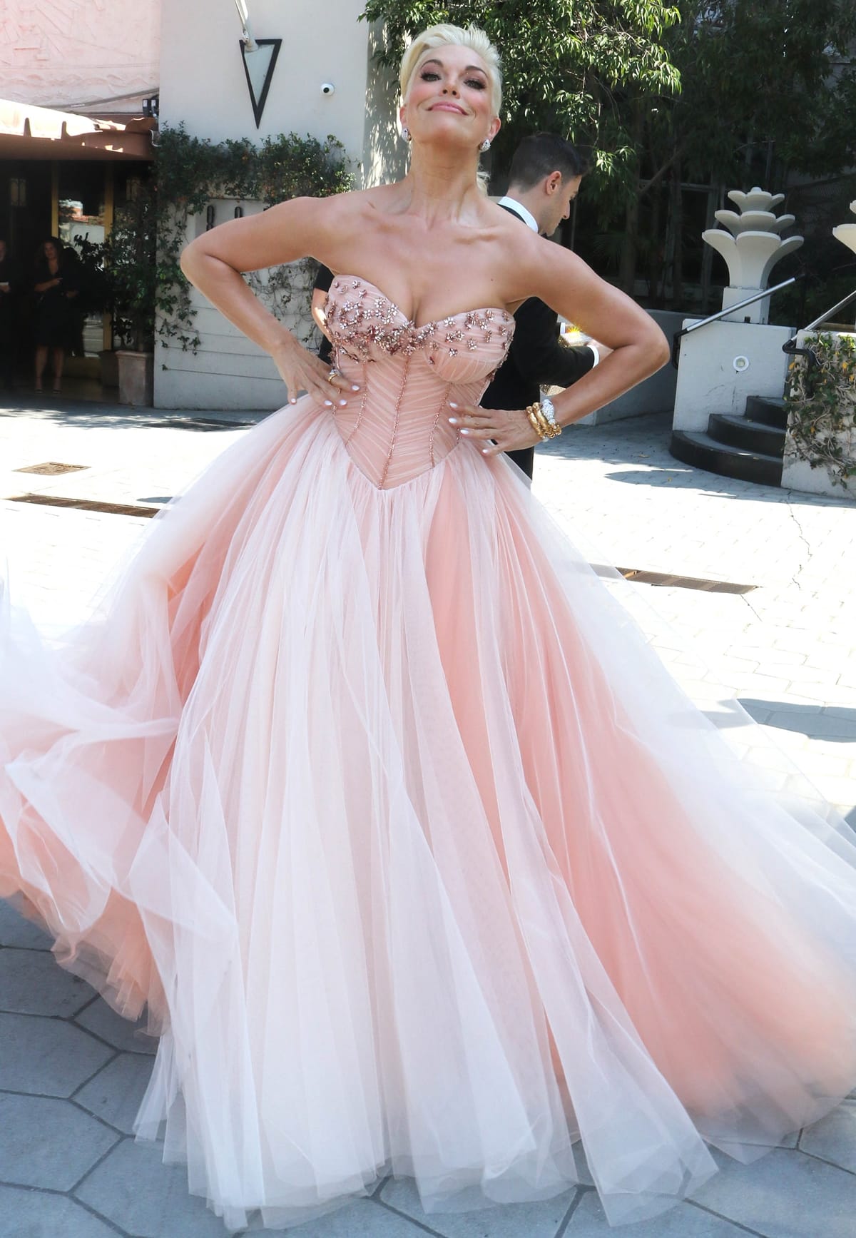 Hannah Waddingham radiates elegance in a blush pink tulle Dolce Gabbana ballgown with a corseted bodice and beaded embellishments ahead of the 2022 Emmy Awards, where she won Outstanding Supporting Actress in a Comedy Series — though her brand-designed crystal sneakers remain hidden beneath the voluminous skirt