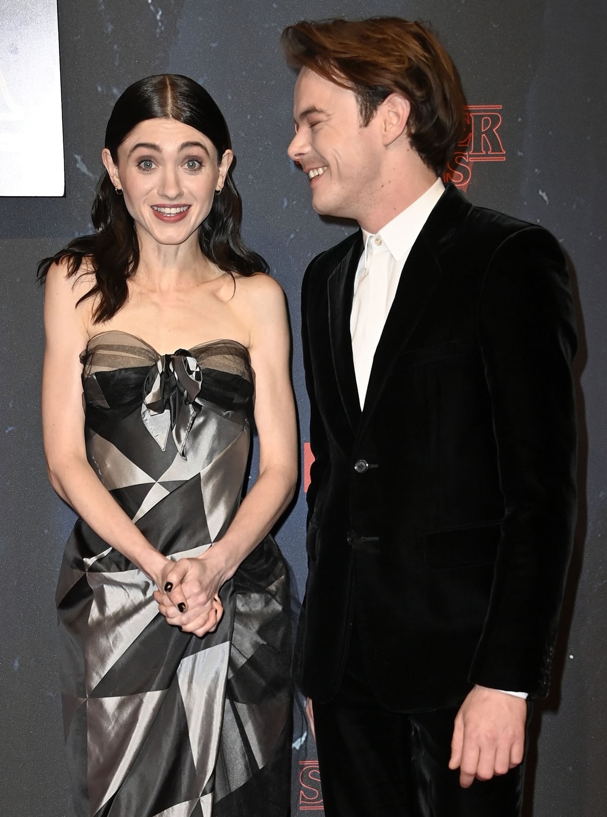 Real-life couple Natalia Dyer and Charlie Heaton brought glamour and charm to the Stranger Things Season 4 premiere, with Dyer stunning in a geometric strapless Vivienne Westwood gown and Heaton looking sharp in a classic black velvet suit