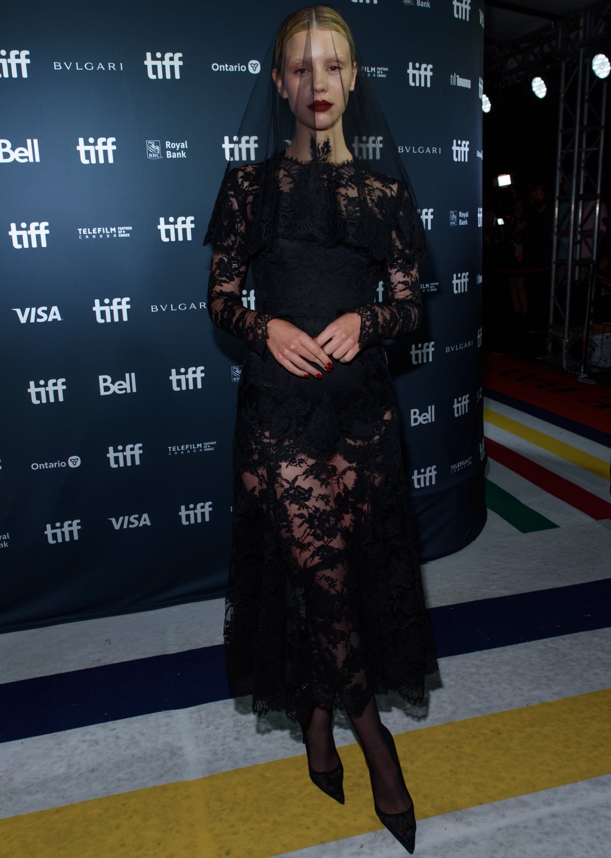 Mia Goth wears a dramatic black lace Dolce Gabbana Alta Moda dress with a matching veil and pointy-toe pumps at the Pearl premiere during the 47th Toronto International Film Festival on September 12, 2022